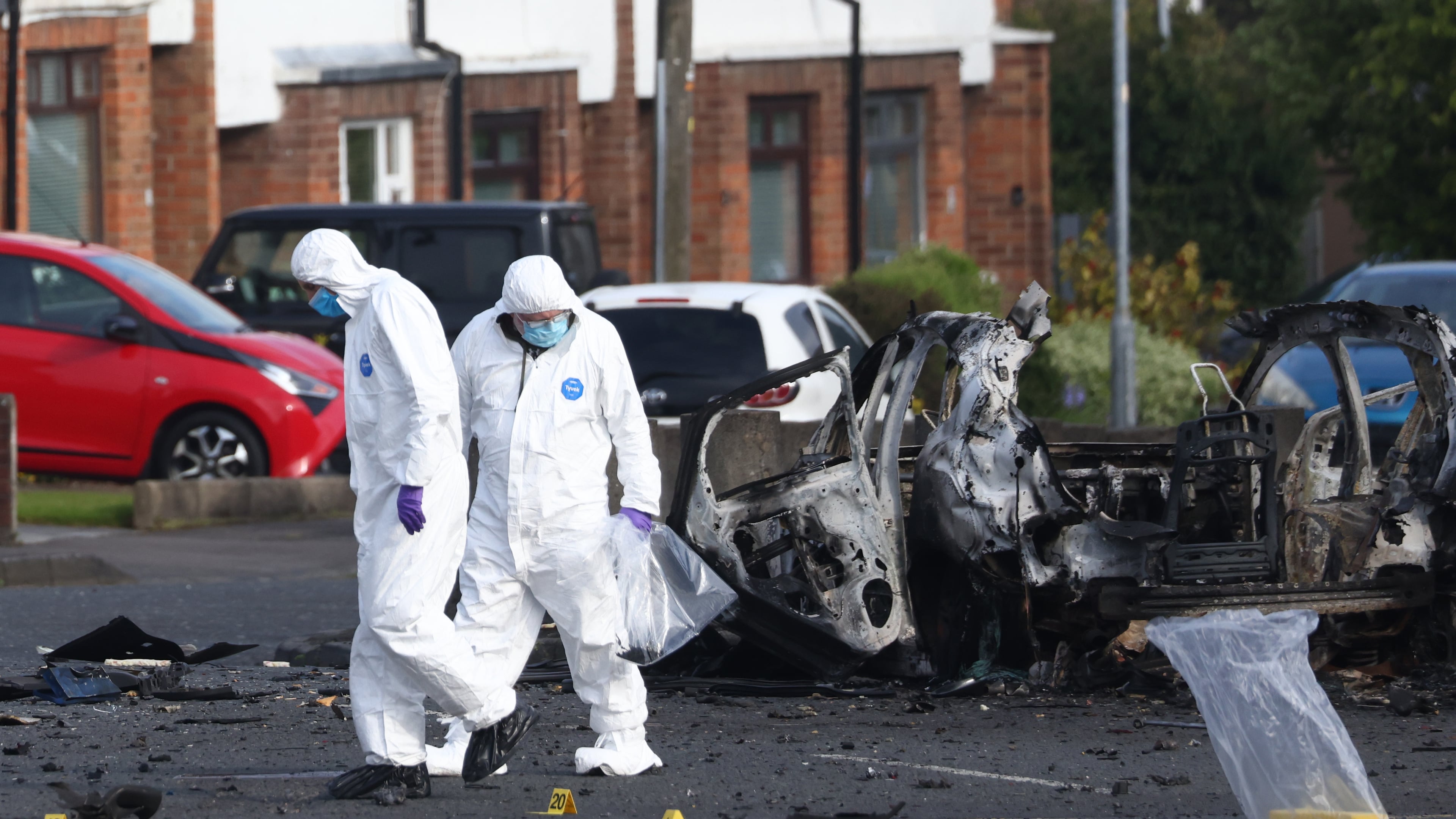 Forensic investigators inspect the site of a car bomb that exploded outside Dunmurry police station in South Belfast, Sunday, April 26, 2026. (AP Photo/Peter Morrison)