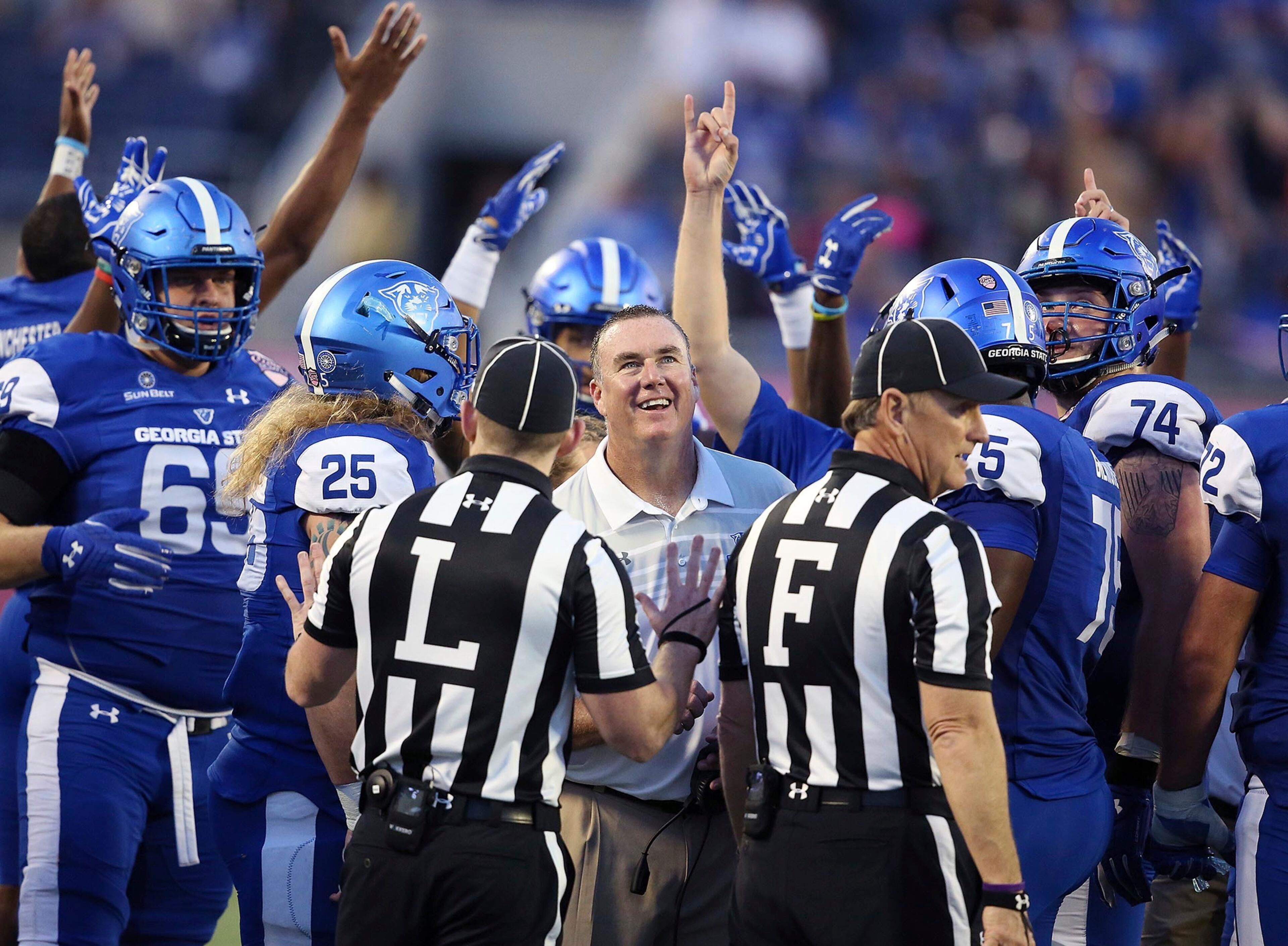 Georgia State head coach Sean Elliott and players celebrate as they watch a replay on the stadium television screen during the Cure Bowl NCAA college football game against Western Kentucky, Saturday, Dec. 16, 2017 in Orlando, Fla. Georgia State won 27-17. (Stephen M. Dowell/Orlando Sentinel via AP)