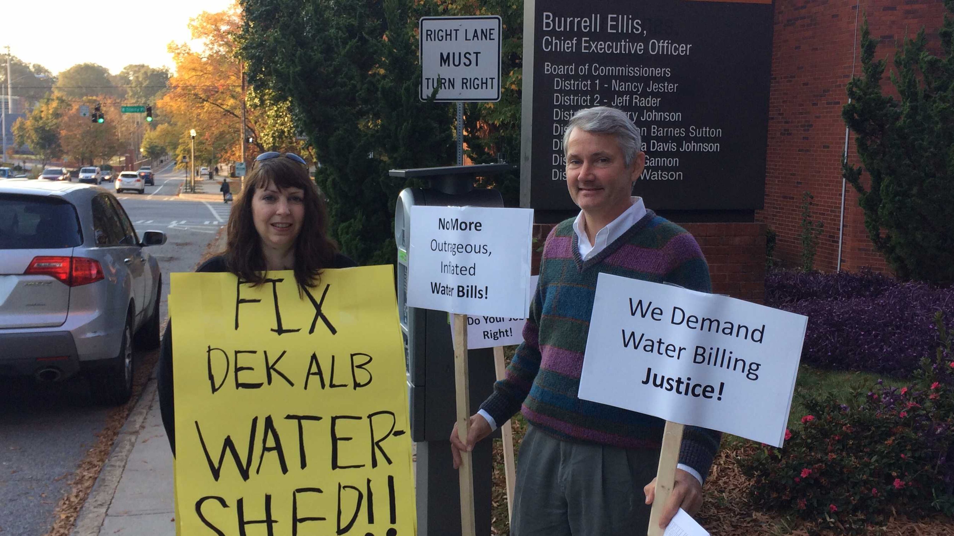 Ellen Buettner and Bill Cox protest DeKalb County’s problem with high water bills outside the Maloof Auditorium last fall. MARK NIESSE / MARK.NIESSE@AJC.COM