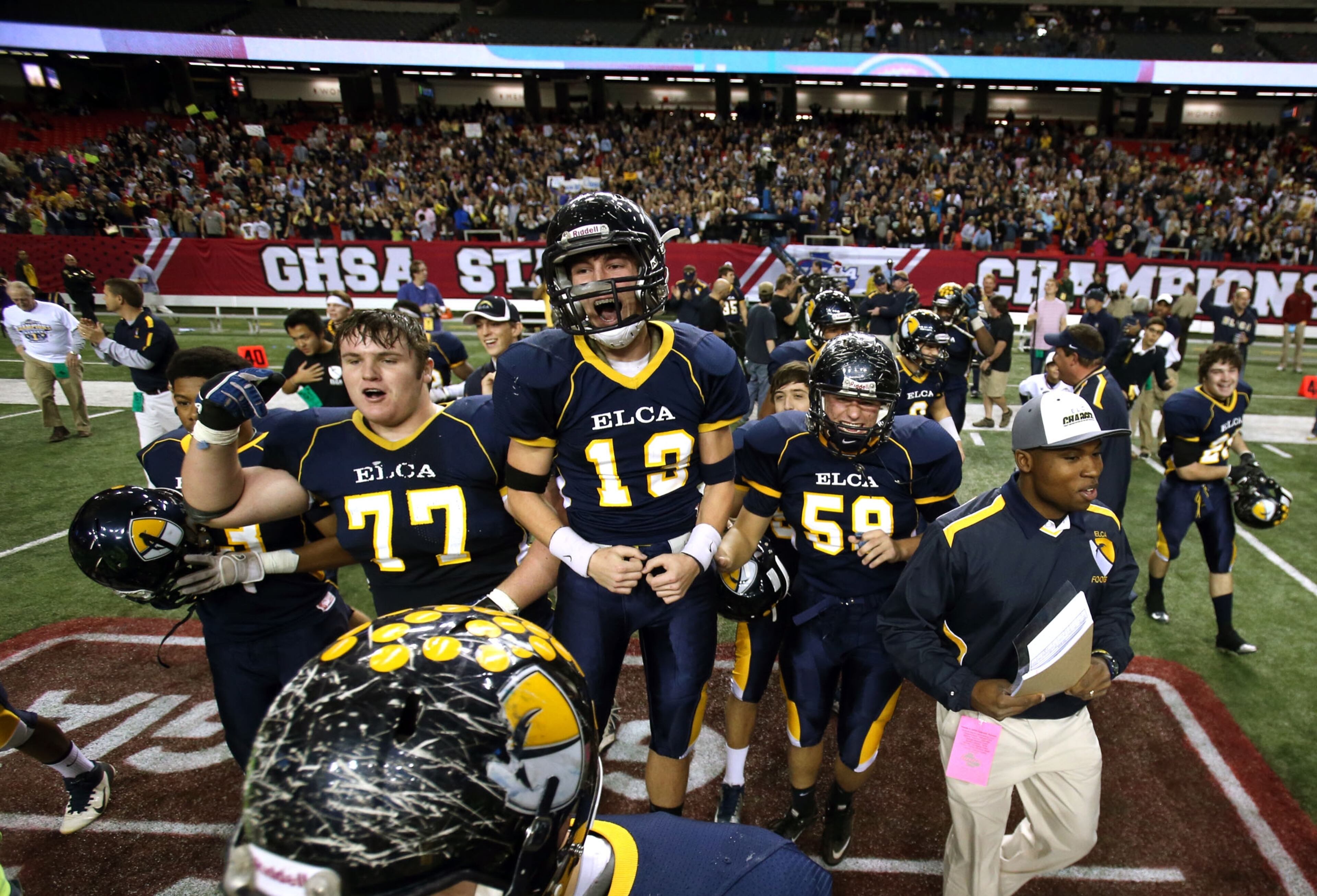 ELCA players (from left to right) Ryan Meneely (77), Ethan McKibbon (13) and Spencer Stefano (59) celebrate as they run onto the field as the final seconds tick off of the clock in the 33-0 victory.