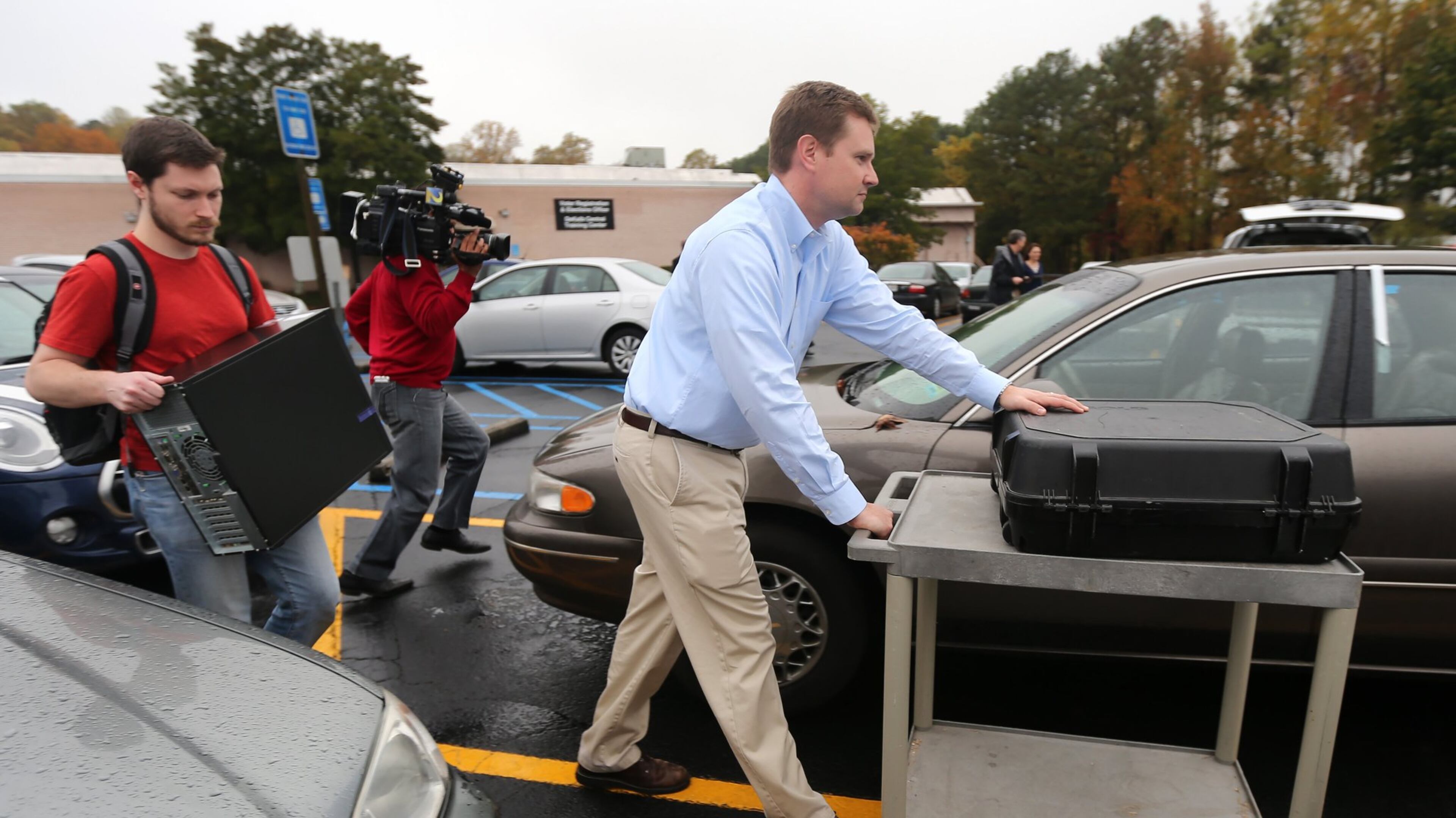 Investigators take a voting machine and a desktop computer from the DeKalb County elections office on Thursday. (Ben Gray / bgray@ajc.com)