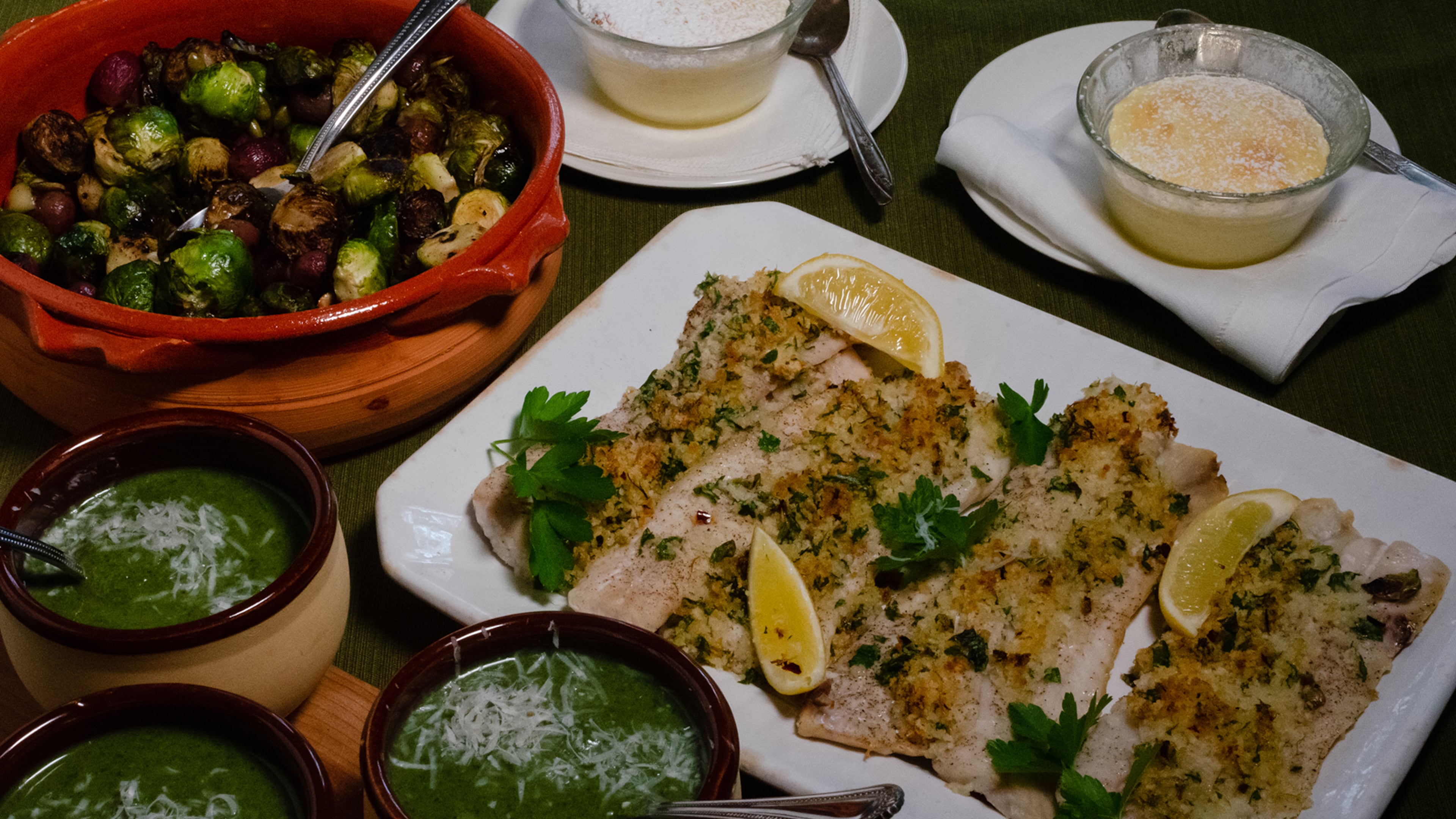 New Year Health Full Meal: (clockwise from upper left) Brussels Sprouts with Garlic and Grapes, Small-Batch Lemon Pudding Cakes, Herb-Crusted Fish Fillets, and Creamy Broccoli Parmesan Soup. (Virginia Willis for The Atlanta Journal-Constitution)