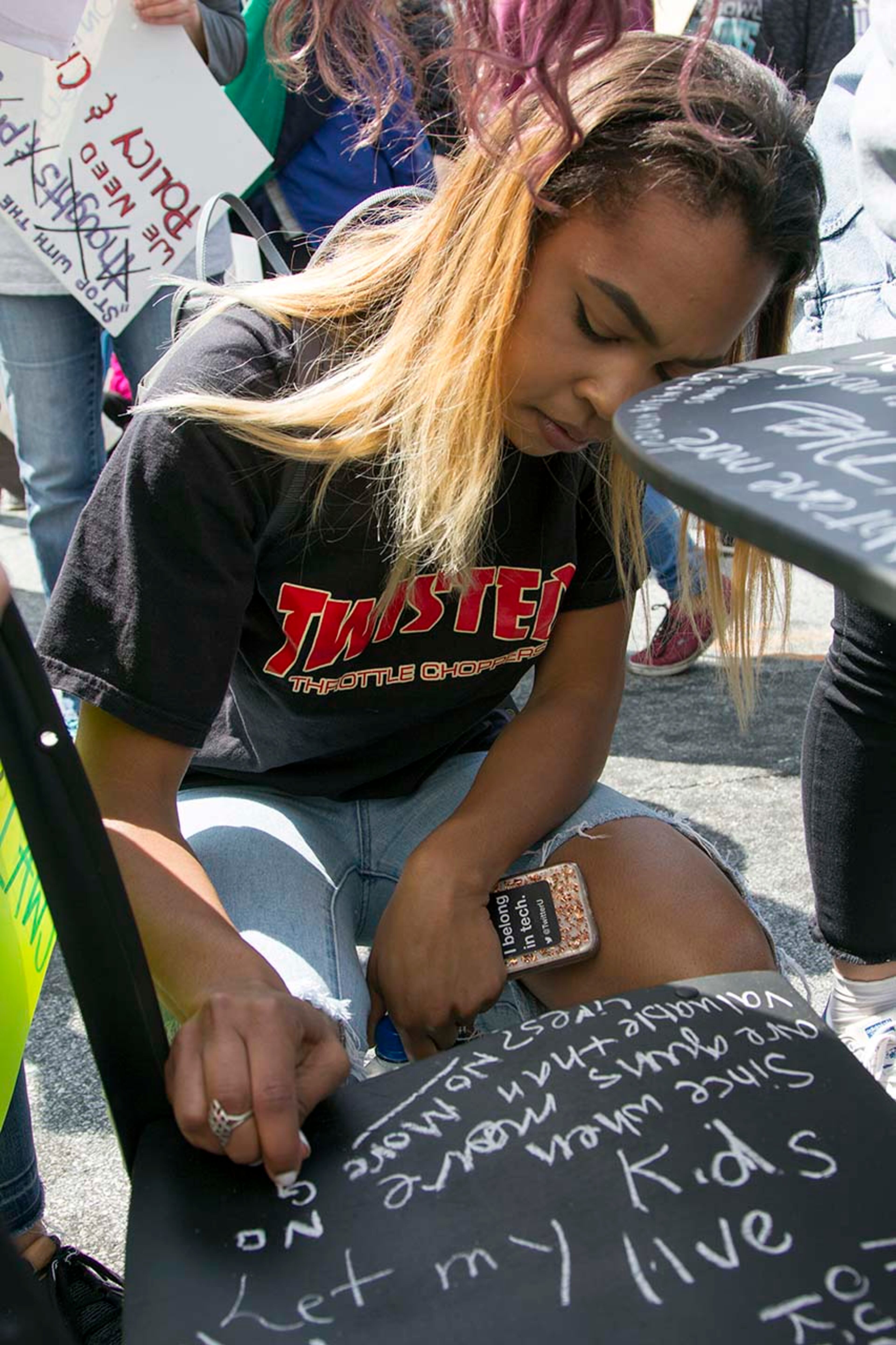 People write on desks placed near the capitol to represent those lost in the Parkland shooting during the March for our Lives event in Atlanta, Georgia, on Saturday, March 24, 2018. (REANN HUBER/REANN.HUBER@AJC.COM)