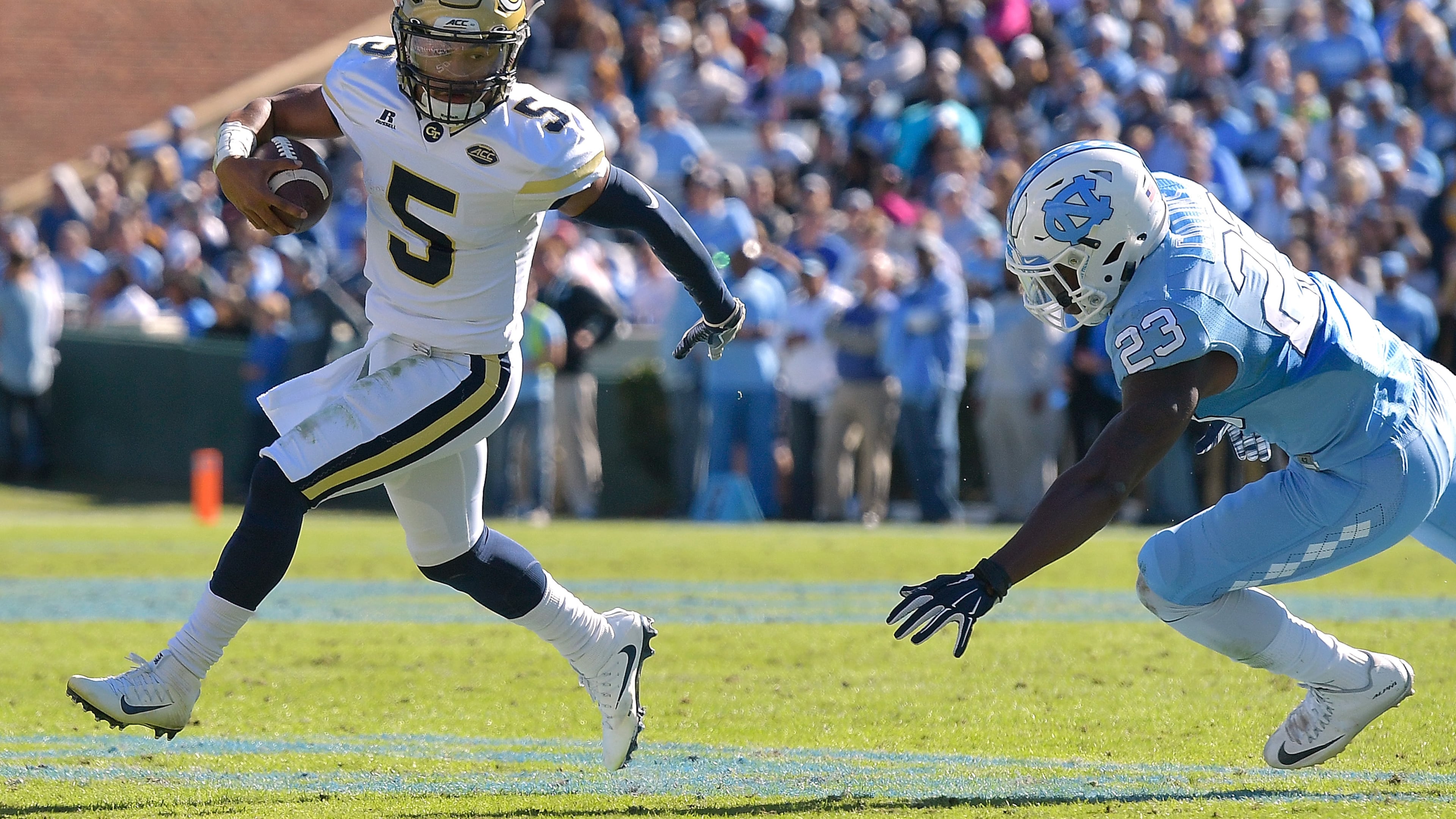 CHAPEL HILL, NC - NOVEMBER 05: Justin Thomas #5 of the Georgia Tech Yellow Jackets rolls out under pressure from Cayson Collins #23 of the North Carolina Tar Heels during the game at Kenan Stadium on November 5, 2016 in Chapel Hill, North Carolina. (Photo by Grant Halverson/Getty Images)
