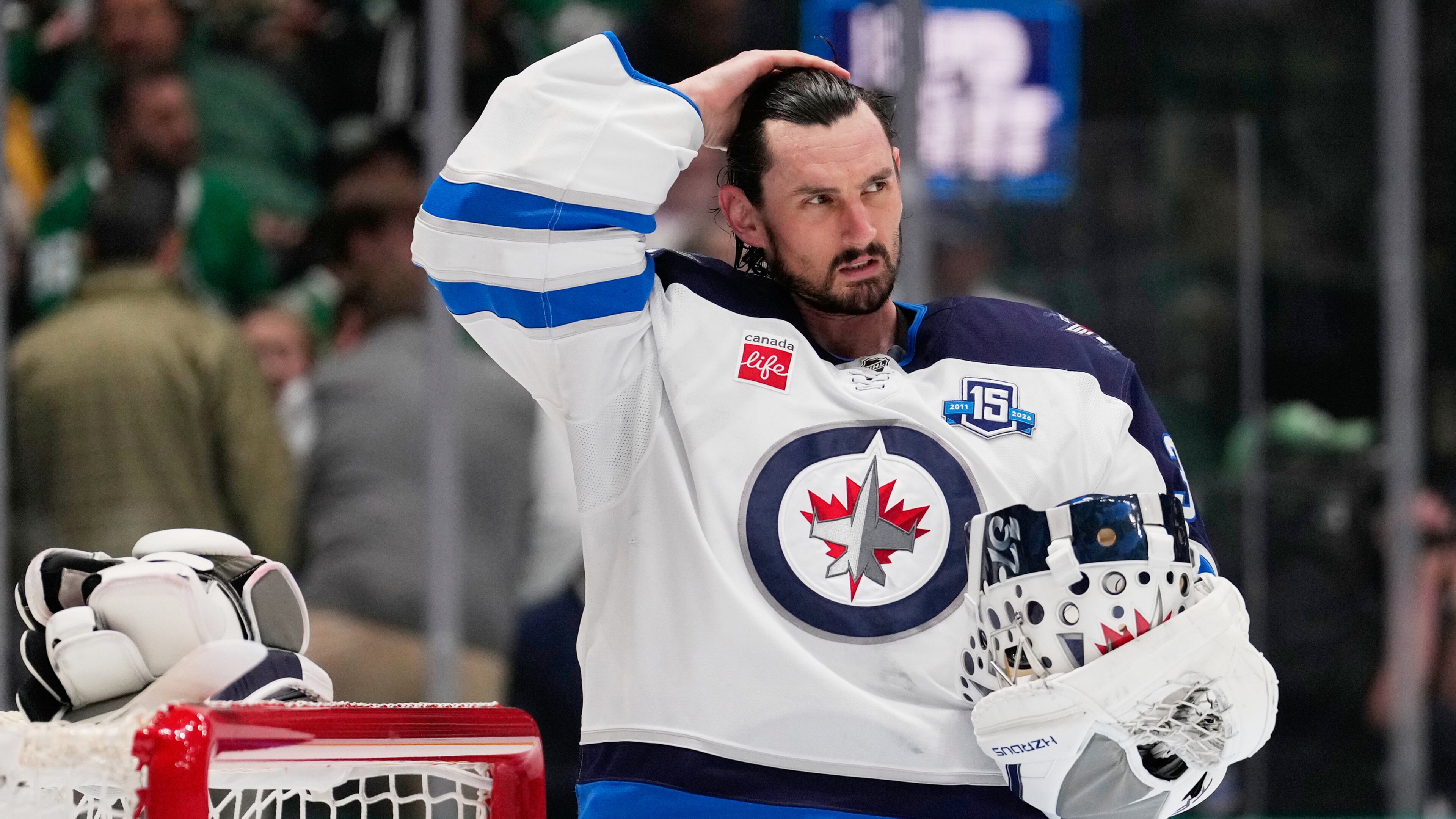FILE - Winnipeg Jets goaltender Connor Hellebuyck stands by the net during a time out from play against the Dallas Stars in the first period of an NHL hockey game, April 2, 2026, in Dallas. (AP Photo/Tony Gutierrez, File)
