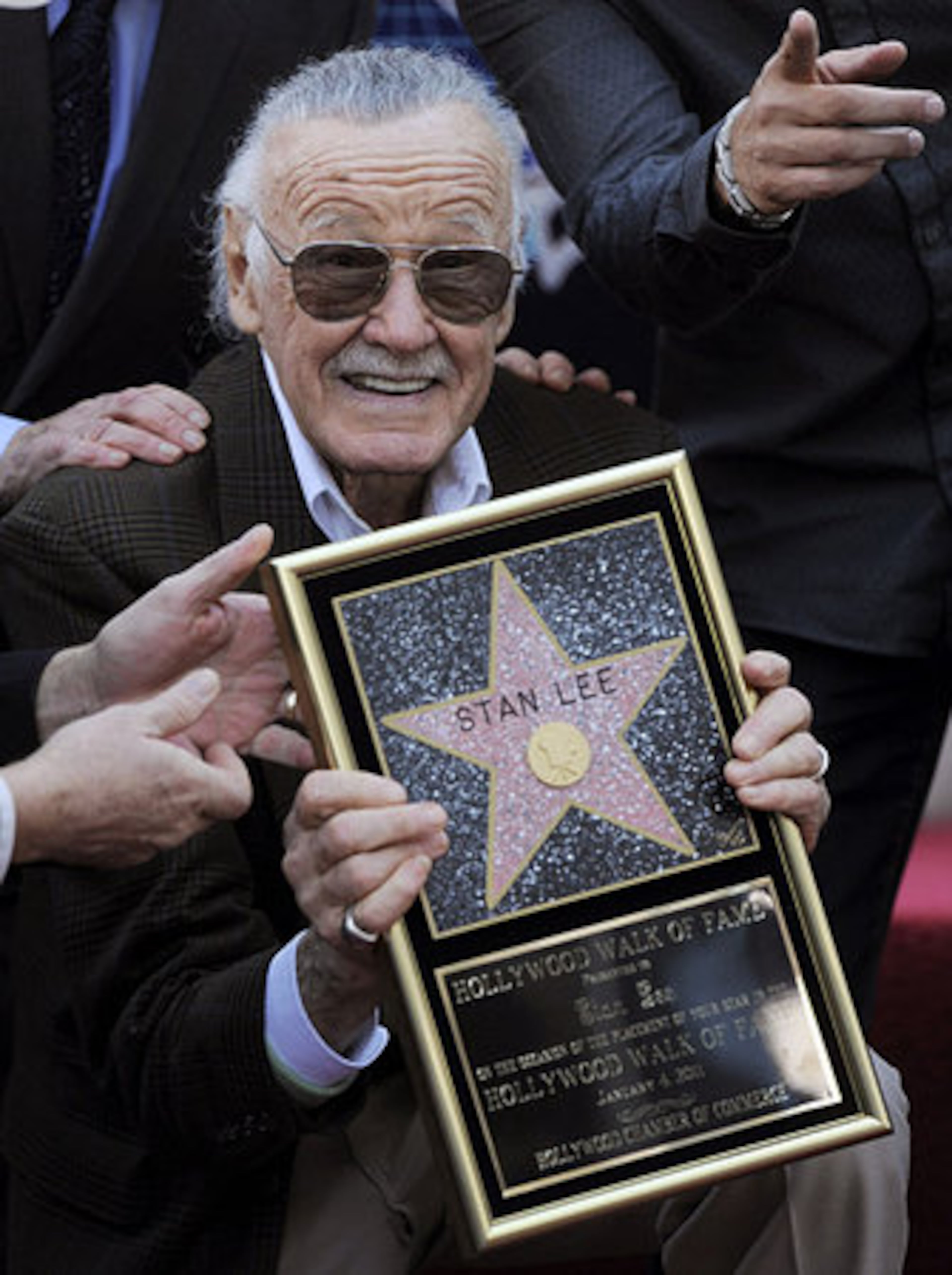 Comic book creator Stan Lee holds up a replica of his new star on the Hollywood Walk of Fame in Los Angeles, Tuesday, Jan. 4, 2011.