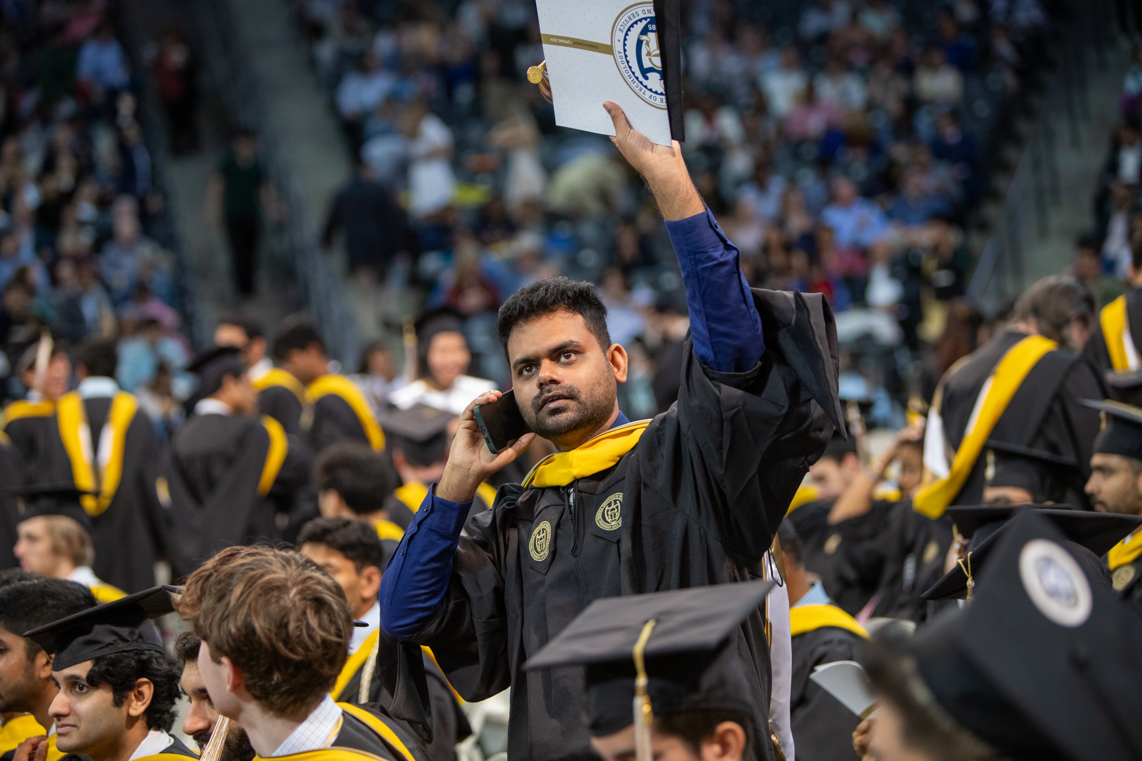 Vijayasai Sanagaram looks to connect with his people during graduation at Georgia Tech in McCamish Pavilion before receiving his Master's degrees from the College of Computing on Saturday, May 4, 2024. (Jenni Girtman for The Atlanta Journal-Constitution)