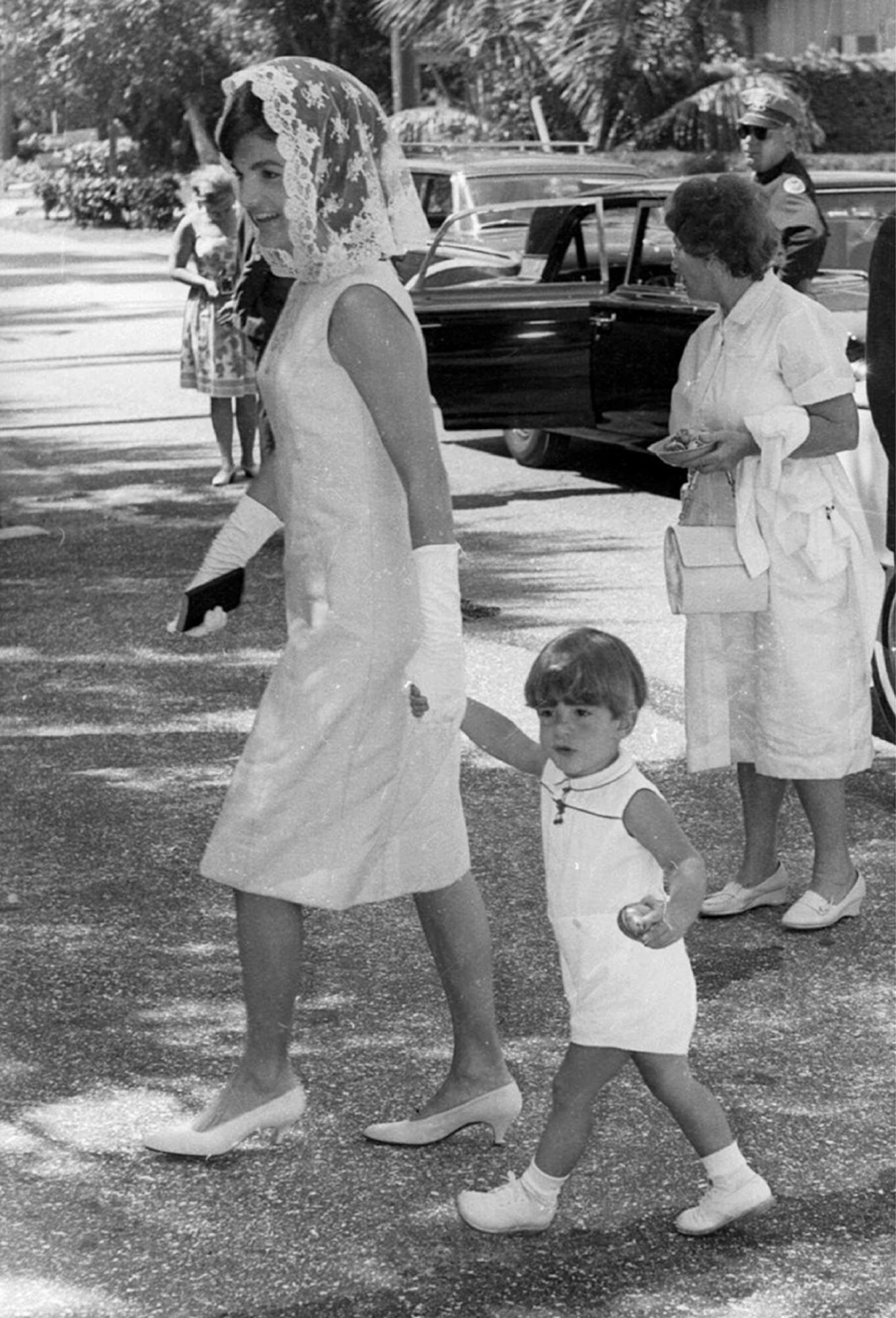 John F. Kennedy Jr. holds the hand of his mother, Jackie Kennedy, in this April 22, 1962 in Palm Beach, Fla. (AP Photo/file)