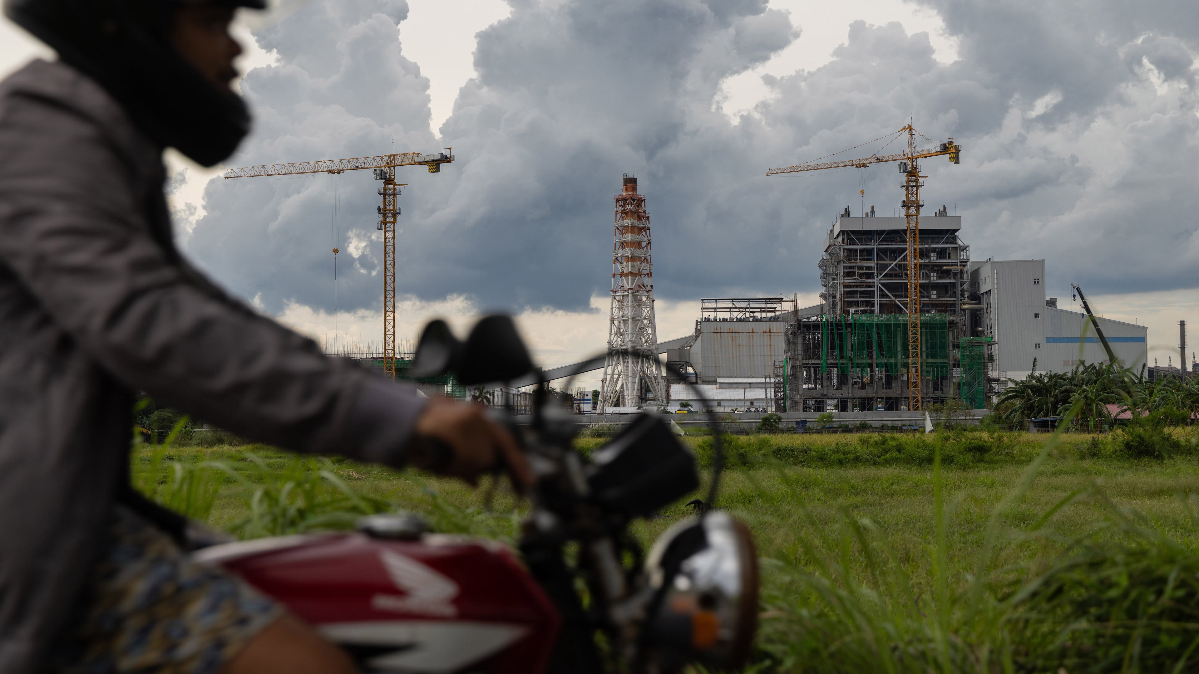 FILE - A motorcyclist drives past the South Luzon Thermal Energy Power Plant in Calaca, Batangas, in the Philippines on Oct. 4, 2025. (AP Photo/Anton L. Delgado, File)
