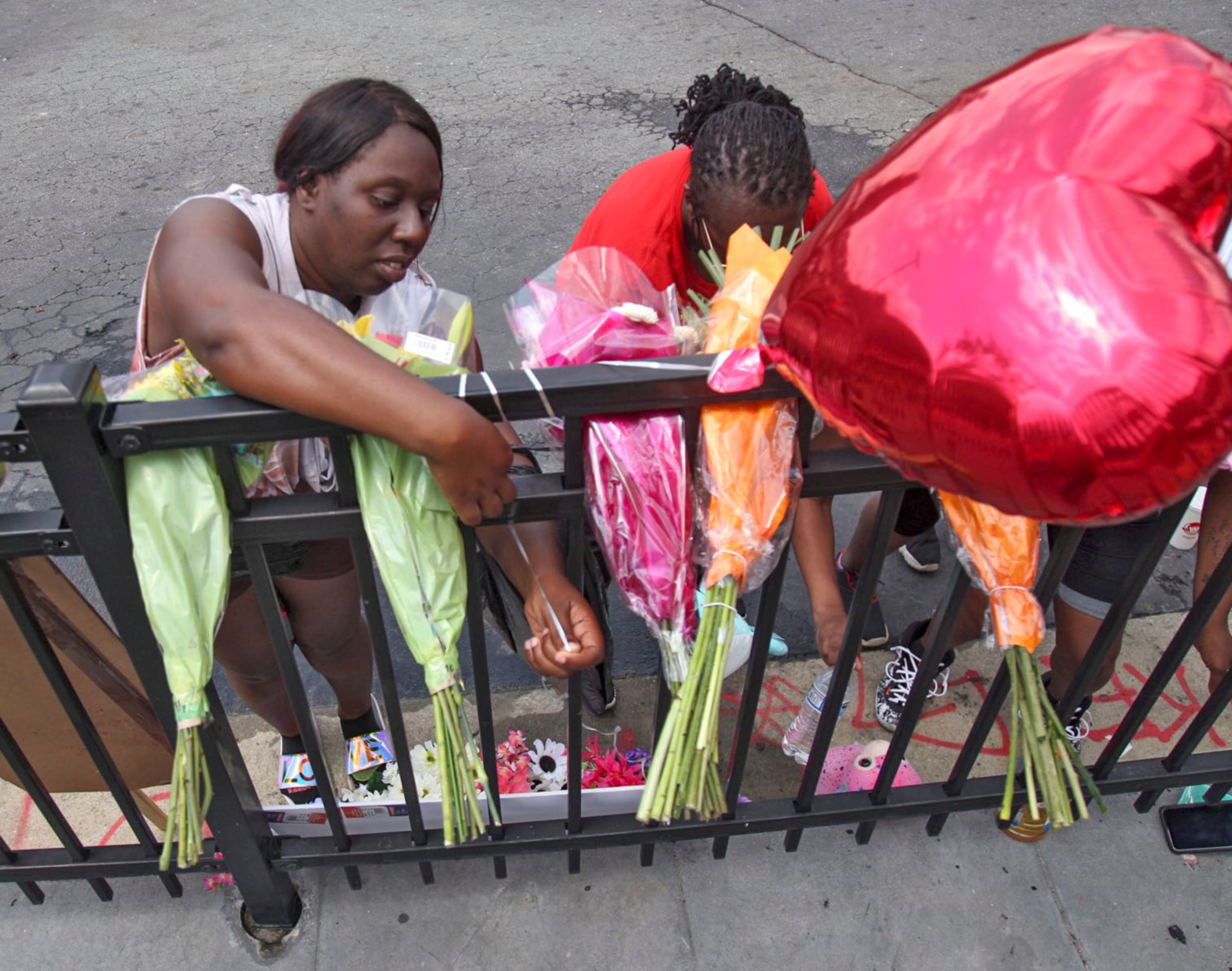 People began showing up at Wendy's on University Avenue Sunday morning, June 14, 2020. Some helped with cleanup, some came to look, and some began placing flowers and created a memorial. (Photo: Steve Schaefer for The Atlanta Journal-Constitution)