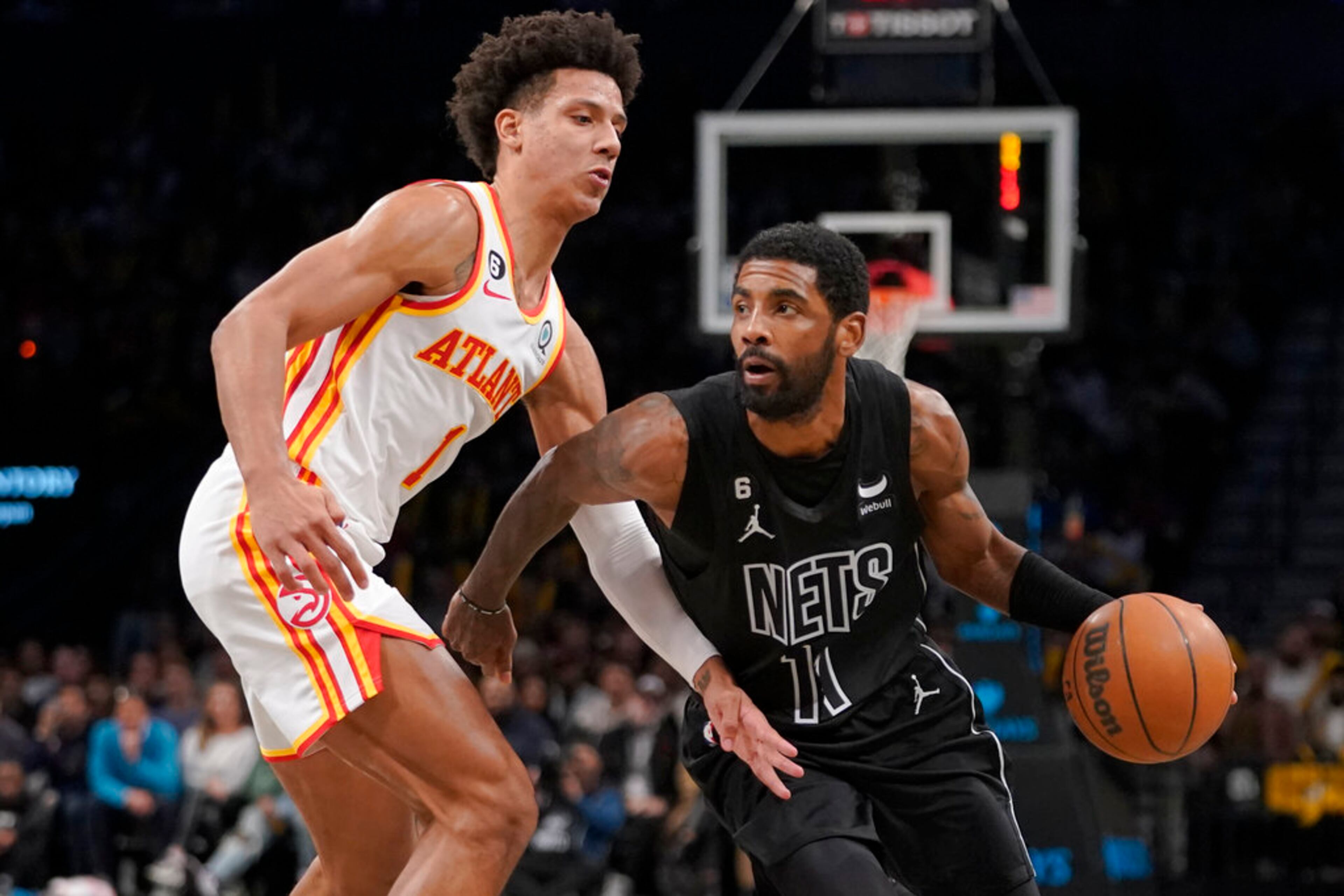 Brooklyn Nets guard Kyrie Irving (11) drives against Atlanta Hawks forward Jalen Johnson (1) during the second half of an NBA basketball game Friday, Dec. 9, 2022, in New York. The Nets won 120-116. (AP Photo/Mary Altaffer)