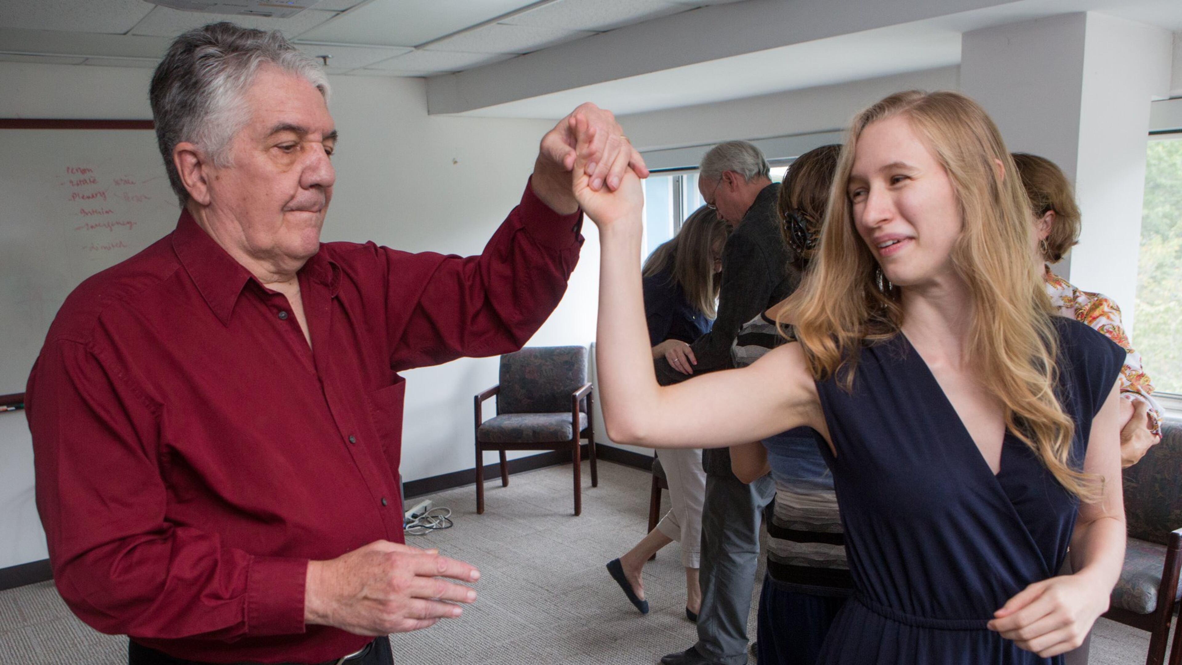 “Repeated studies have shown that adapted tango improves balance, mobility, endurance … spatial cognition and quality of life,” says Madeleine Hackney. Here, Larry Bullard twirls Ariel Hart during a dance therapy group session. (Photo by Phil Skinner)