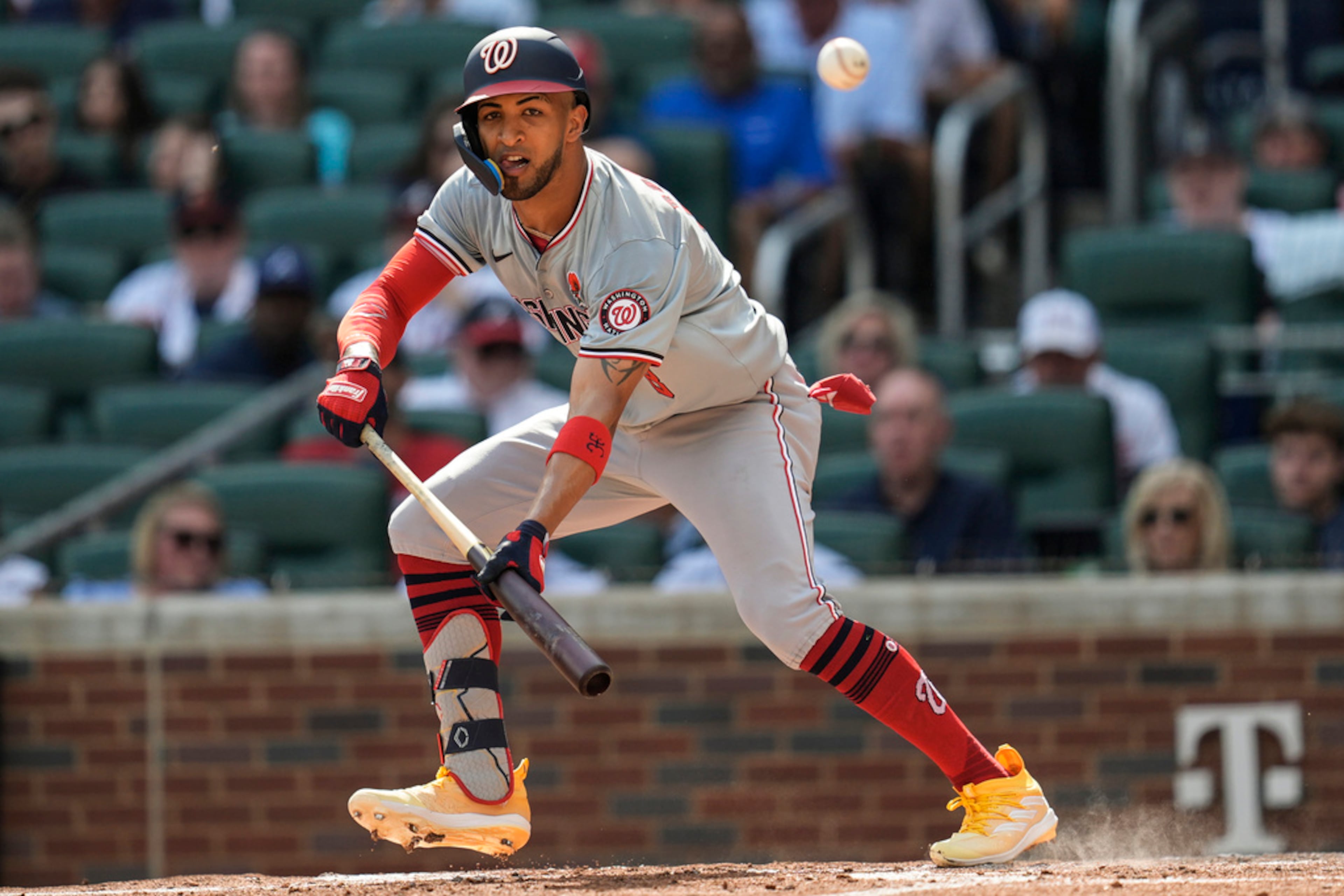 Washington Nationals' Eddie Rosario (8) attempts a bunt in the second inning of a baseball game against the Atlanta Braves, Monday, May 27, 2024, in Atlanta. (AP Photo/Mike Stewart)