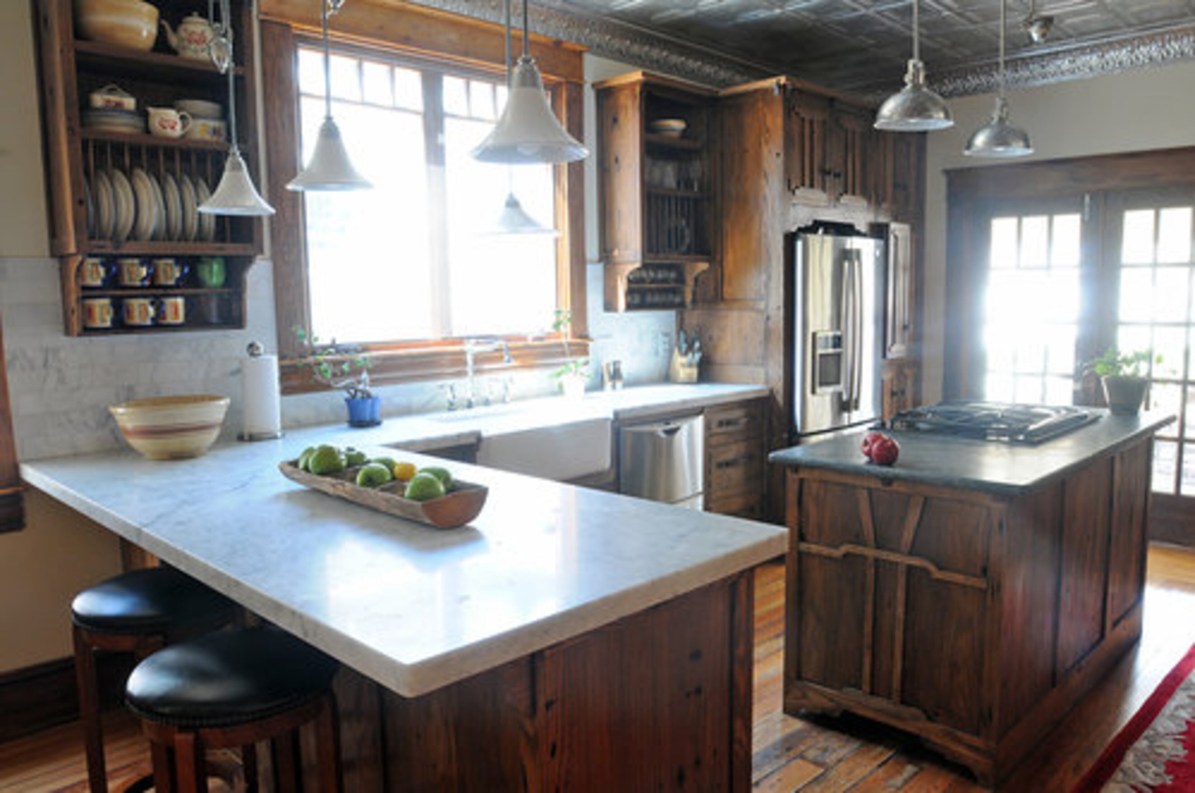 In the kitchen, the main cabinets are milled from reclaimed oak floor house joists and feature walnut accents and drawers and have an embedded civil war era bullet in the island panel.