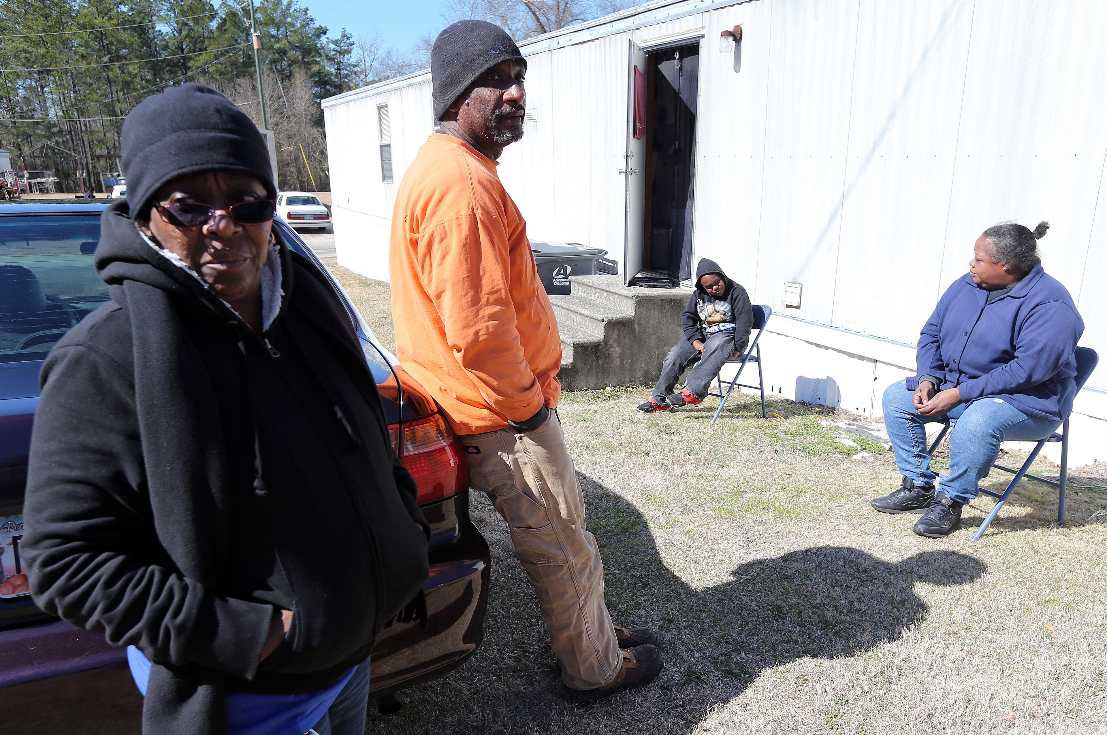 Grovetown residents Henrietta Wearrien, from left, Clinton Raiford, Emarion Boyd, 8, and Deborah Raiford were still without power Saturday afternoon February 15, 2014 and were outside of their trailers trying to soak up some sun to warm up. The group said it was warmer outside than inside their trailers. BEN GRAY / BGRAY@AJC.COM