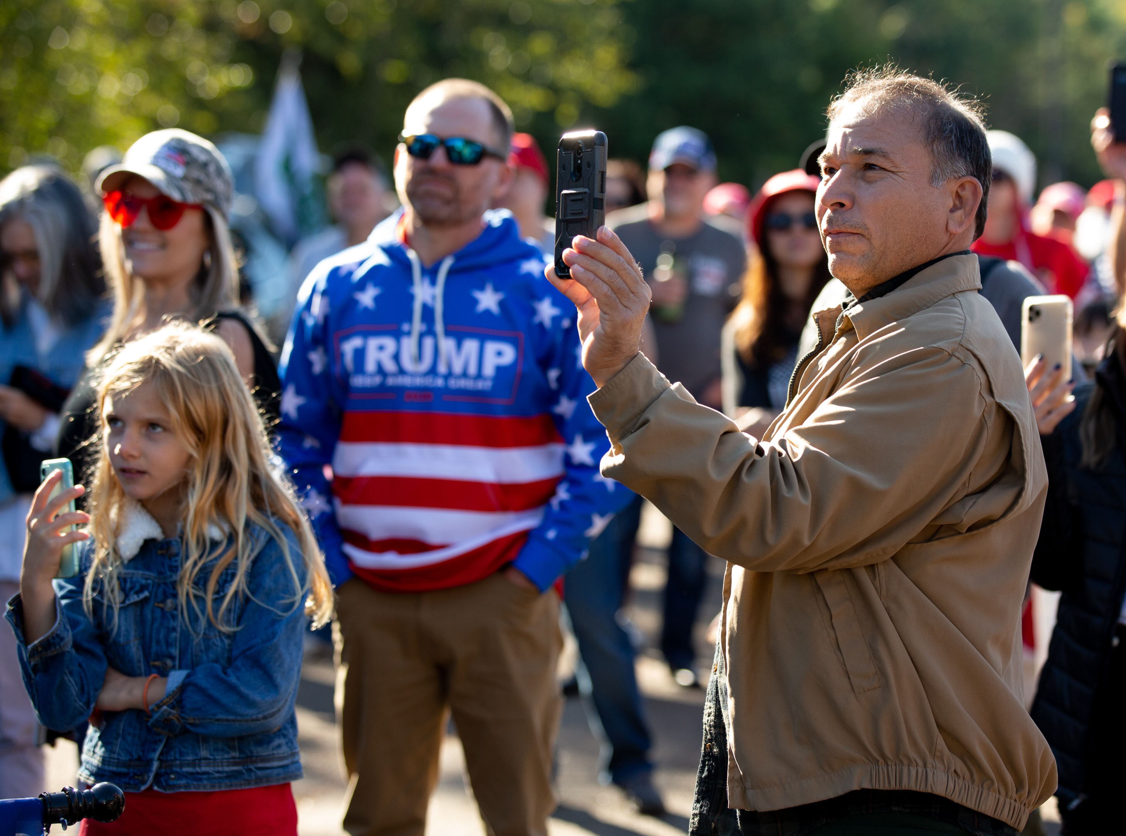Rally goers take photographs and listen to the speakers at the MAGA Drag the Interstate event in support of President Trump in Kennesaw on Saturday, October 3, 2020. STEVE SCHAEFER / SPECIAL TO THE AJC