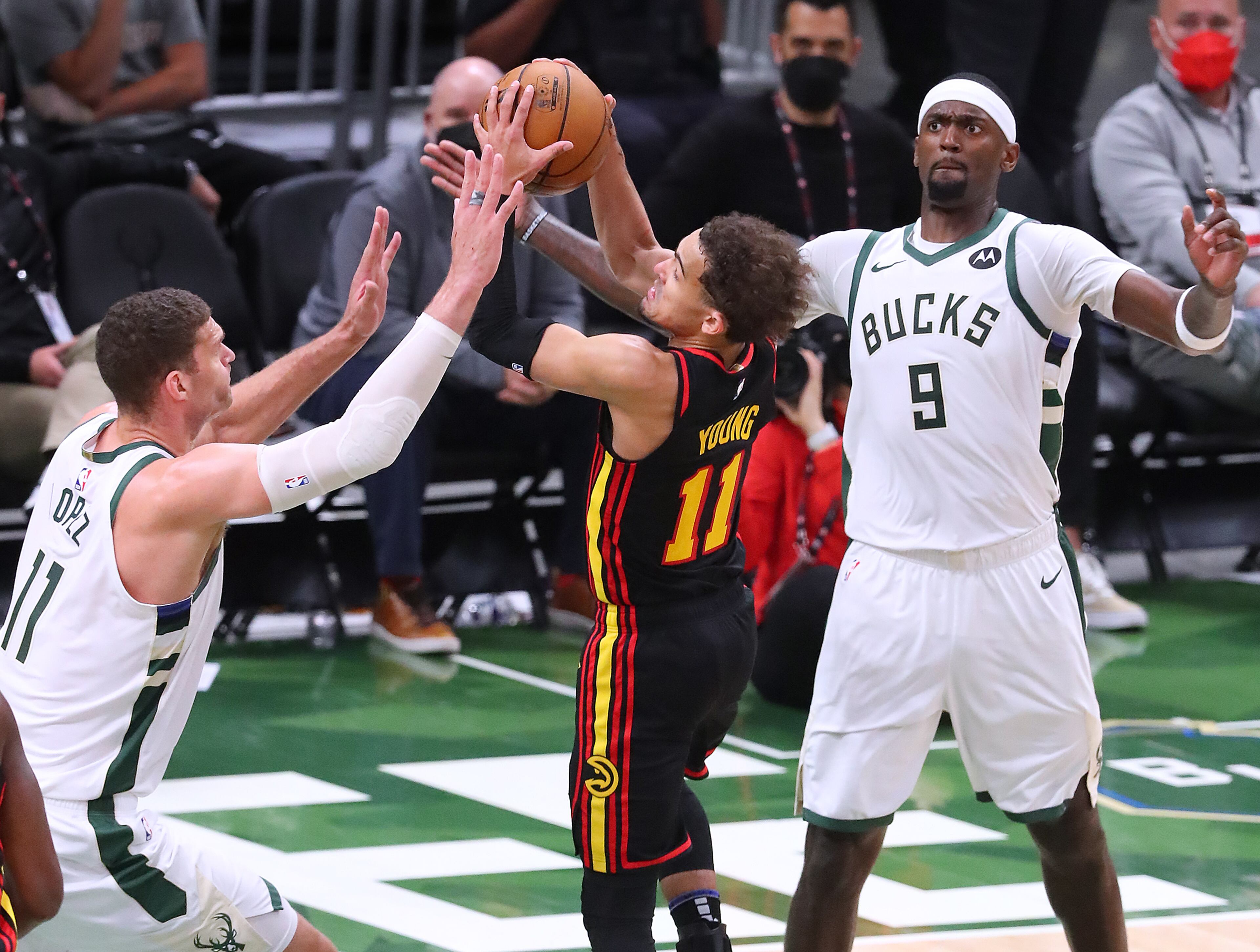Milwaukee Bucks defender Brook Lopez (left) forces a turnover by Atlanta Hawks guard Trae Young. “Curtis Compton / Curtis.Compton@ajc.com”