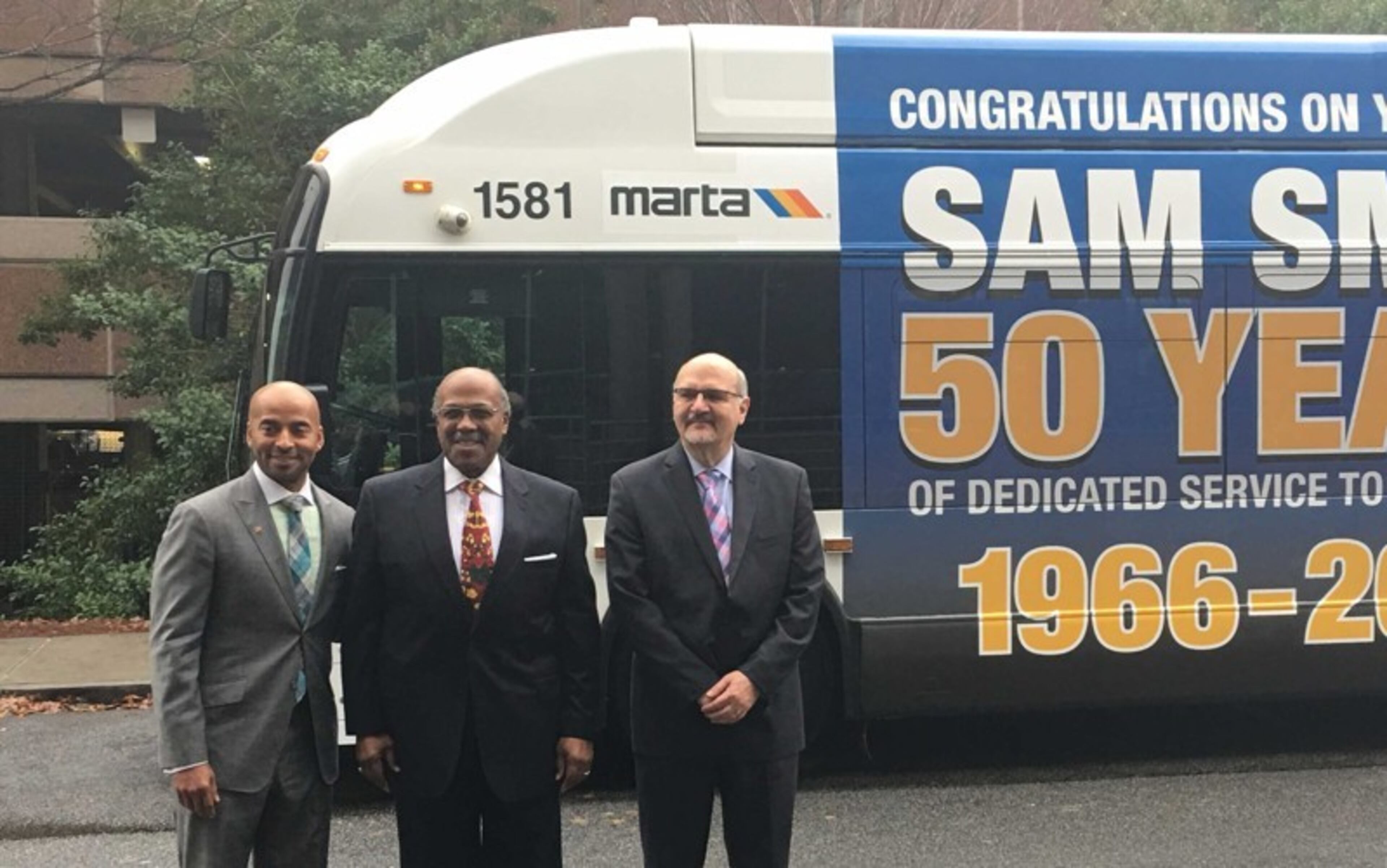 MARTA CEO Keith Parker (left), Sam Smith (center) and COO Rich Krisak pose for a photo in front of a bus dedicated to Smith when he retired. He's planning to earn a degree in organizational leadership at Morris Brown College.