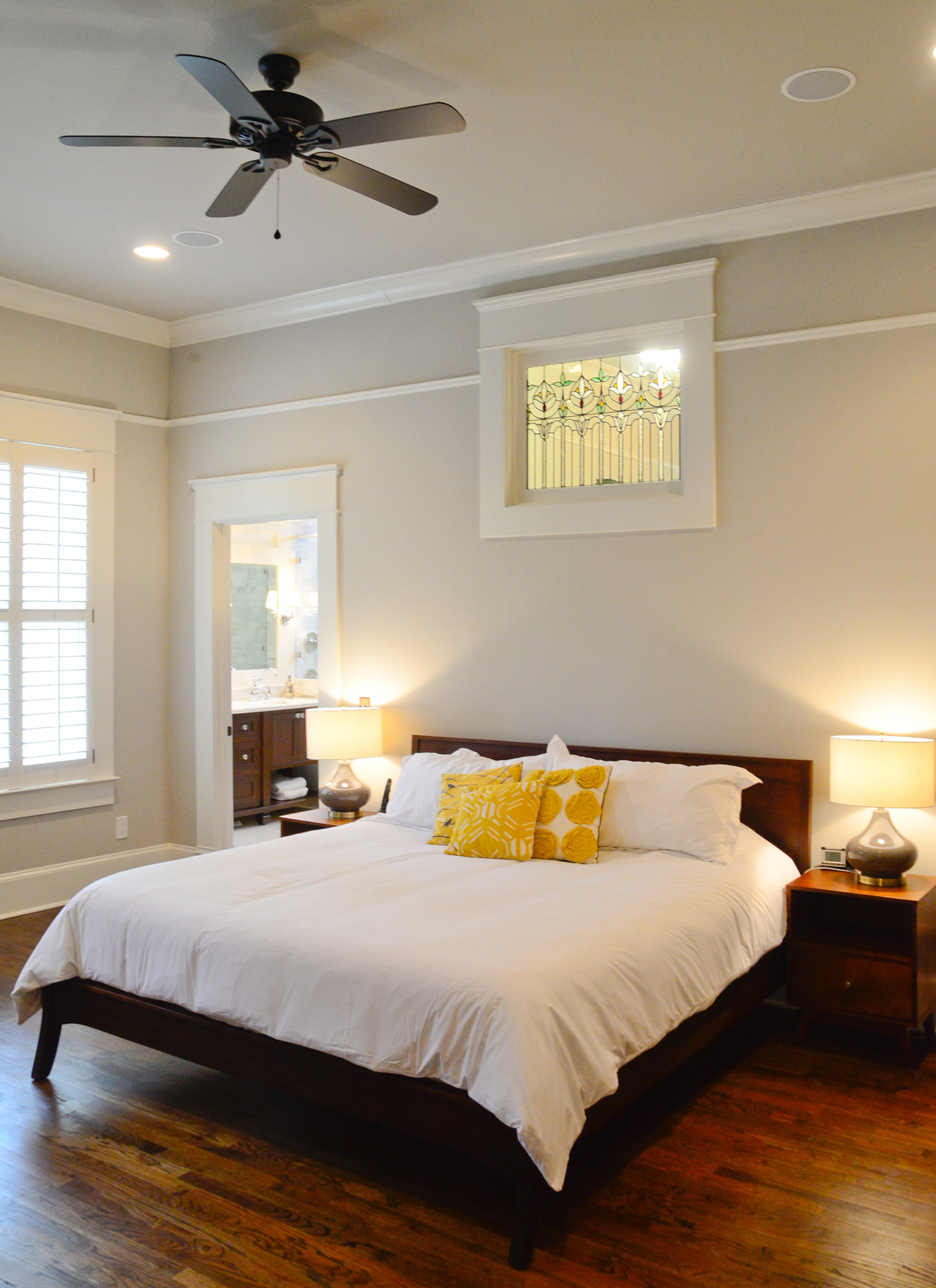 There's a custom bed in the master bedroom, which has stained glass that fits with the home's post-Victorian-era time period. The walls are painted Sherwin-Williams' Agreeable Gray.