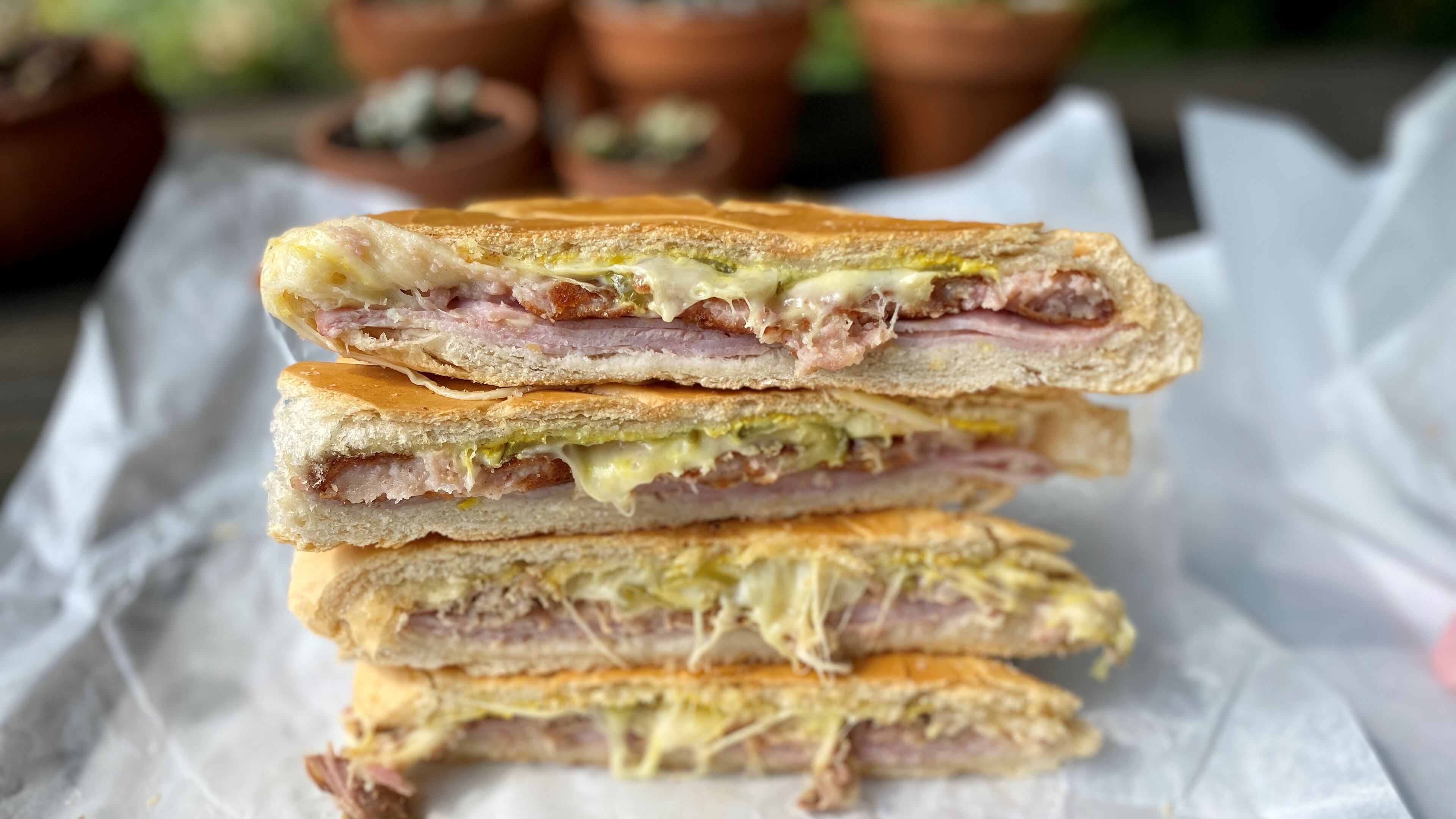 Buena Gente Cuban Bakery makes its own sandwich bread for its pressed sandwiches, such as the croqueta preparada (top two wedges) and the classic Cuban (bottom two). Wendell Brock for The Atlanta Journal-Constitution