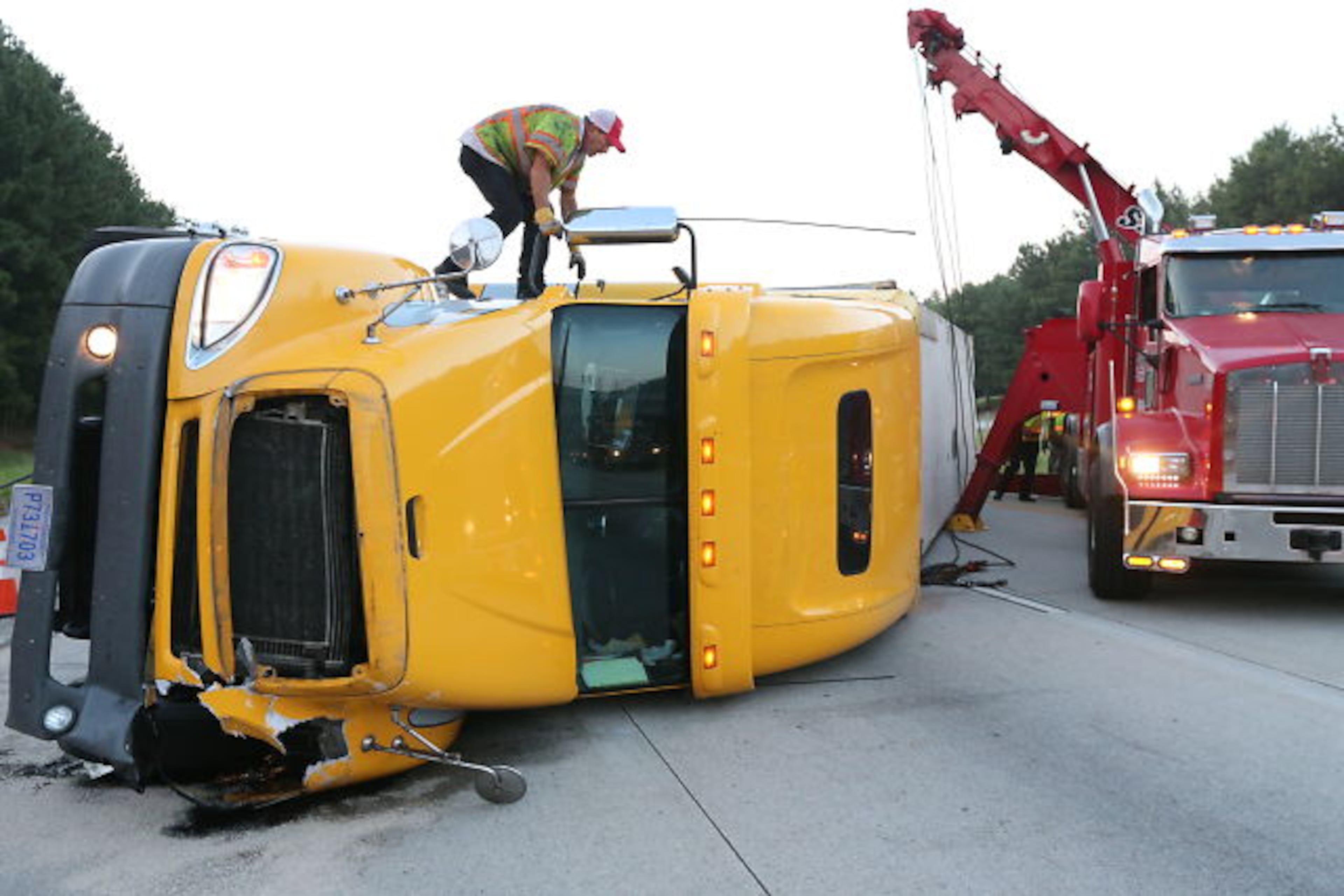 An overturned tractor-trailer shut down I-675 northbound in Clayton County during the early stages of the June 19 morning commute. JOHN SPINK / JSpink@ajc.com