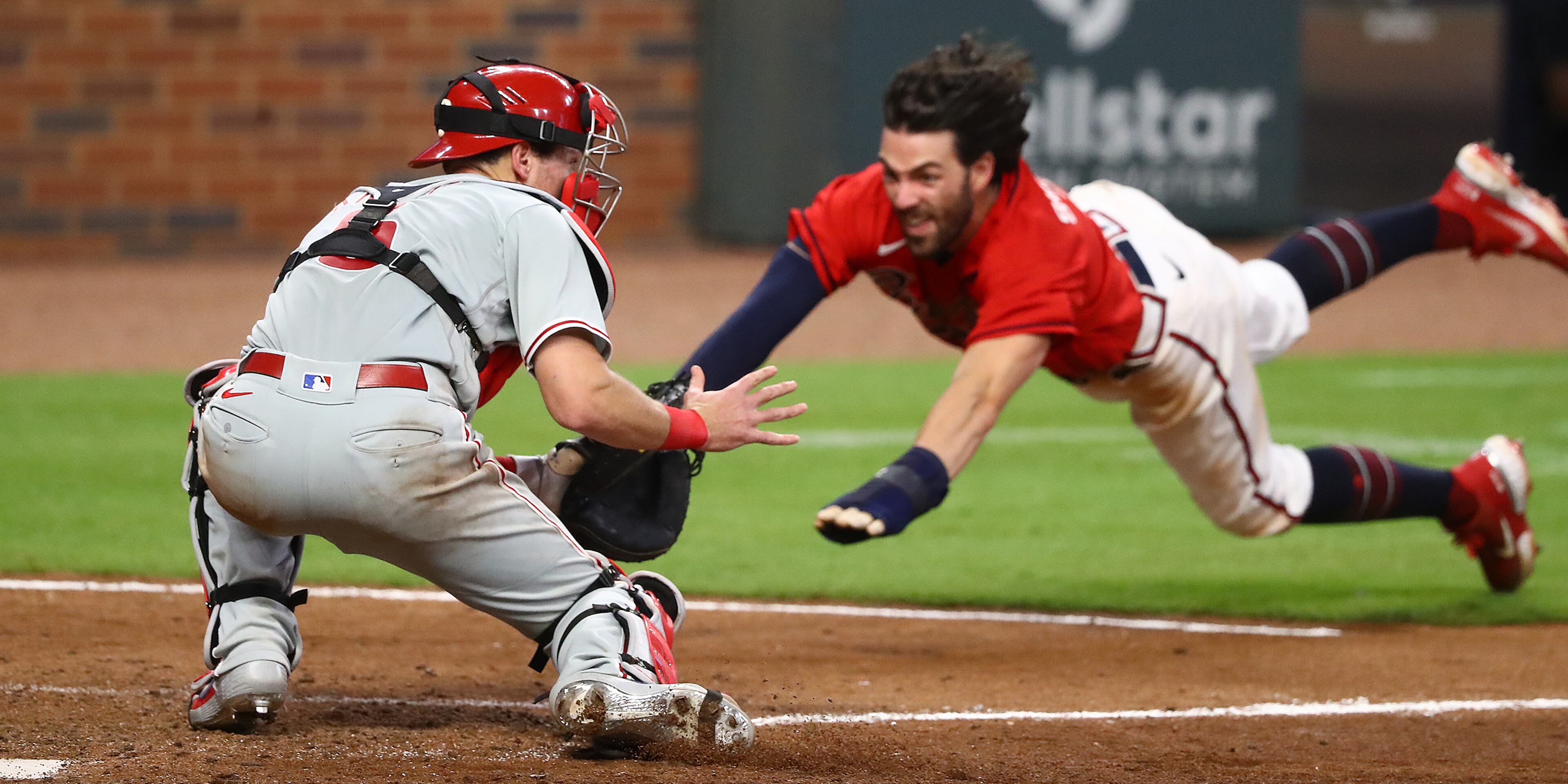 Atlanta Braves Dansby Swanson dives home while Philadelphia Phillies catcher Andrew Knapp waits for the throw during the ninth inning in a MLB baseball game on Sunday, August 23, 2020 in Atlanta. Swanson was called out to end the game 5-4. Curtis Compton ccompton@ajc.com