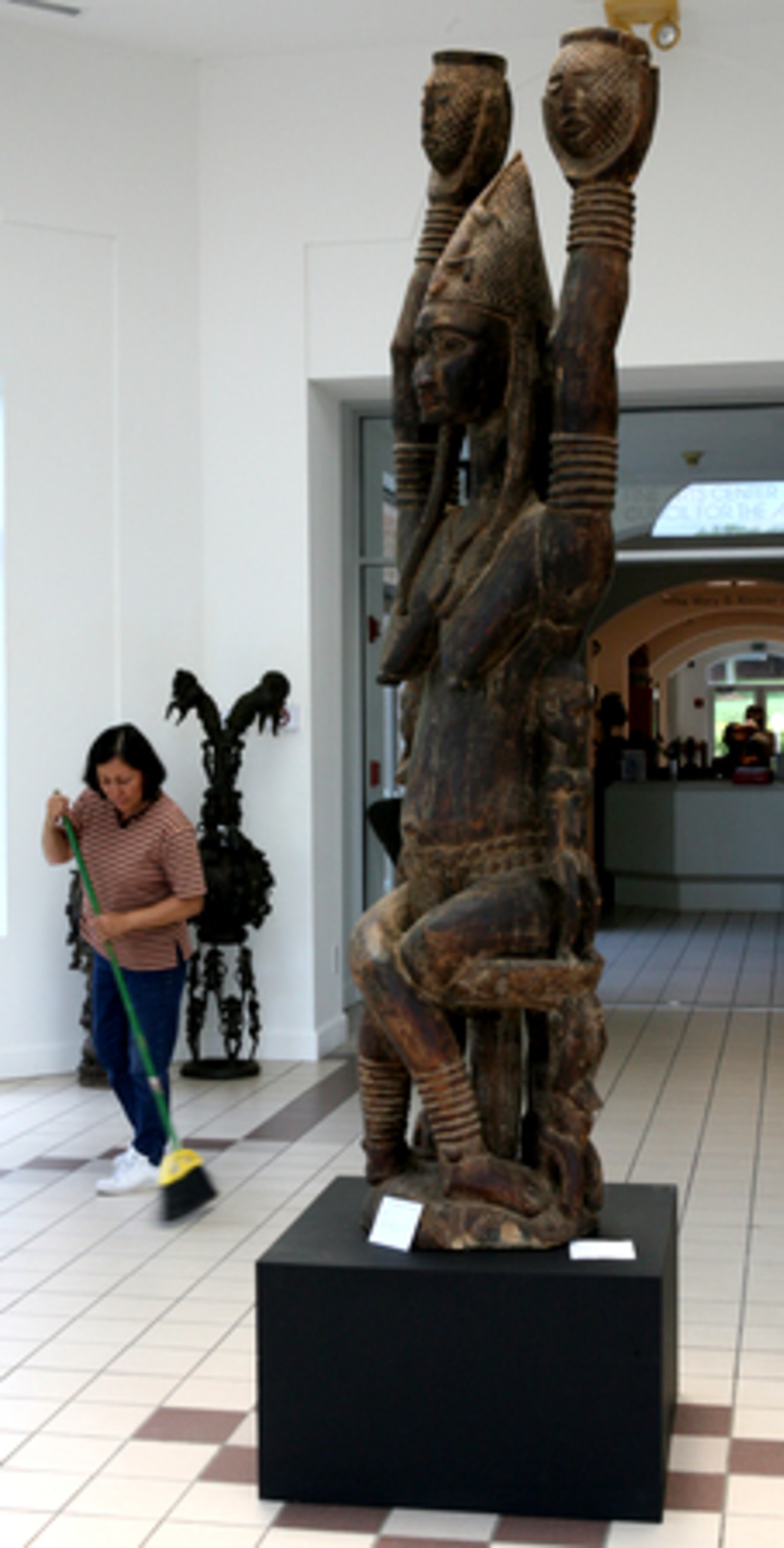 Ana Clavijo sweeps up as she and the staff at The Hudgens Center for the Arts in Duluth prepare for the opening of the Susan and William Rochfort Collection. The piece in foreground is a ngandusa figure from the Bambara people of Mali. It is carved from one piece of wood and stands seven feet, ten inches tall. Offerings would be placed at the base of the figure to insure fertility and continued lineage.