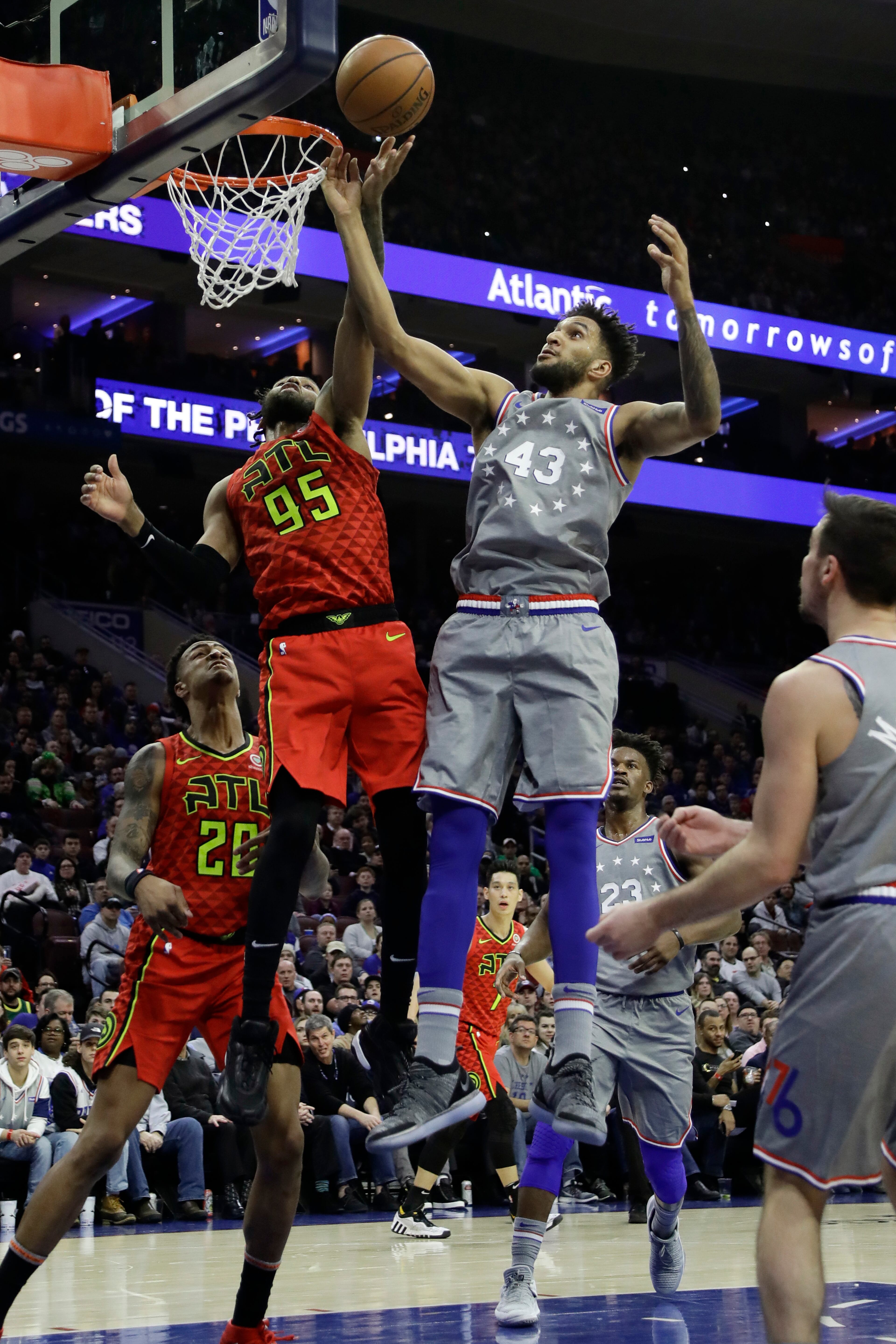 Philadelphia 76ers' Jonah Bolden (43) and Atlanta Hawks' DeAndre' Bembry (95) leap for a rebound during the first half of an NBA basketball game Friday, Jan. 11, 2019, in Philadelphia. (AP Photo/Matt Slocum)