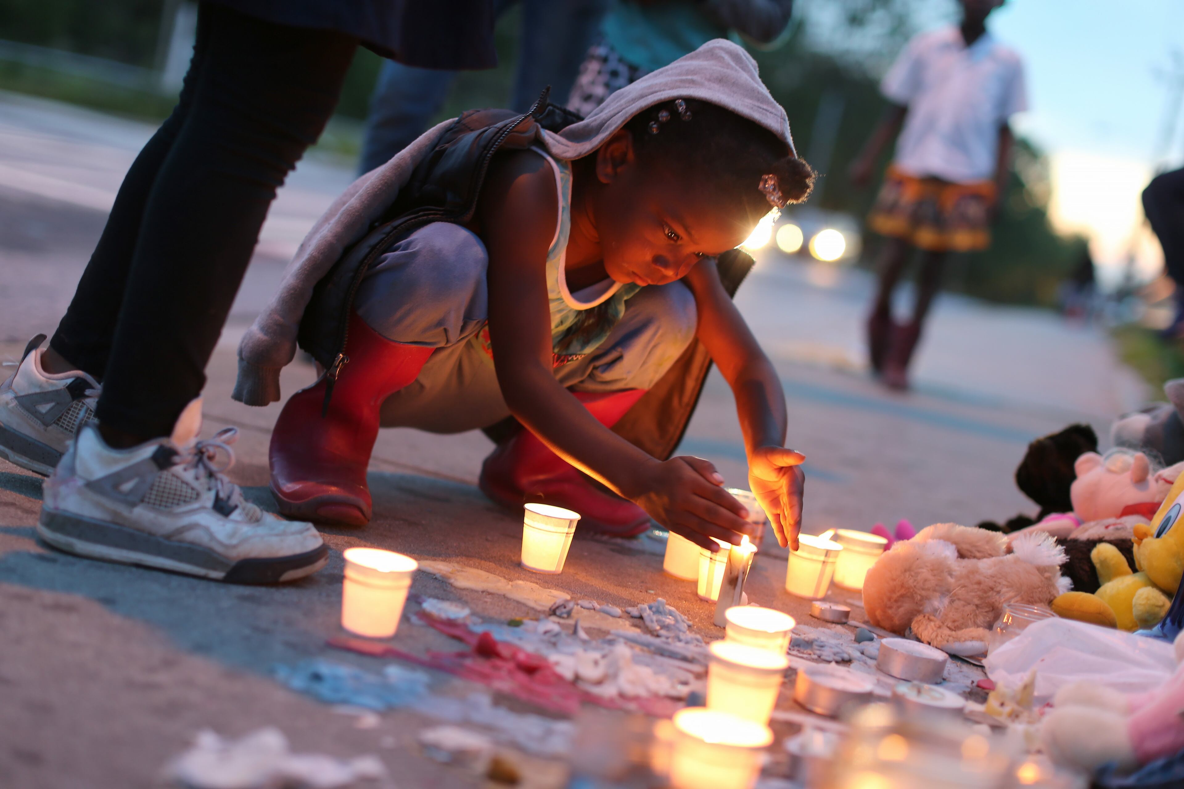 Samarah Bagby, 8, stares at a candle during a vigil for Isaiah Ward on Wednesday evening April 20, 2016. Ward was hit and killed while walking on the Atlanta sidewalk with his brother and a friend last Friday evening. Ben Gray / bgray@ajc.com