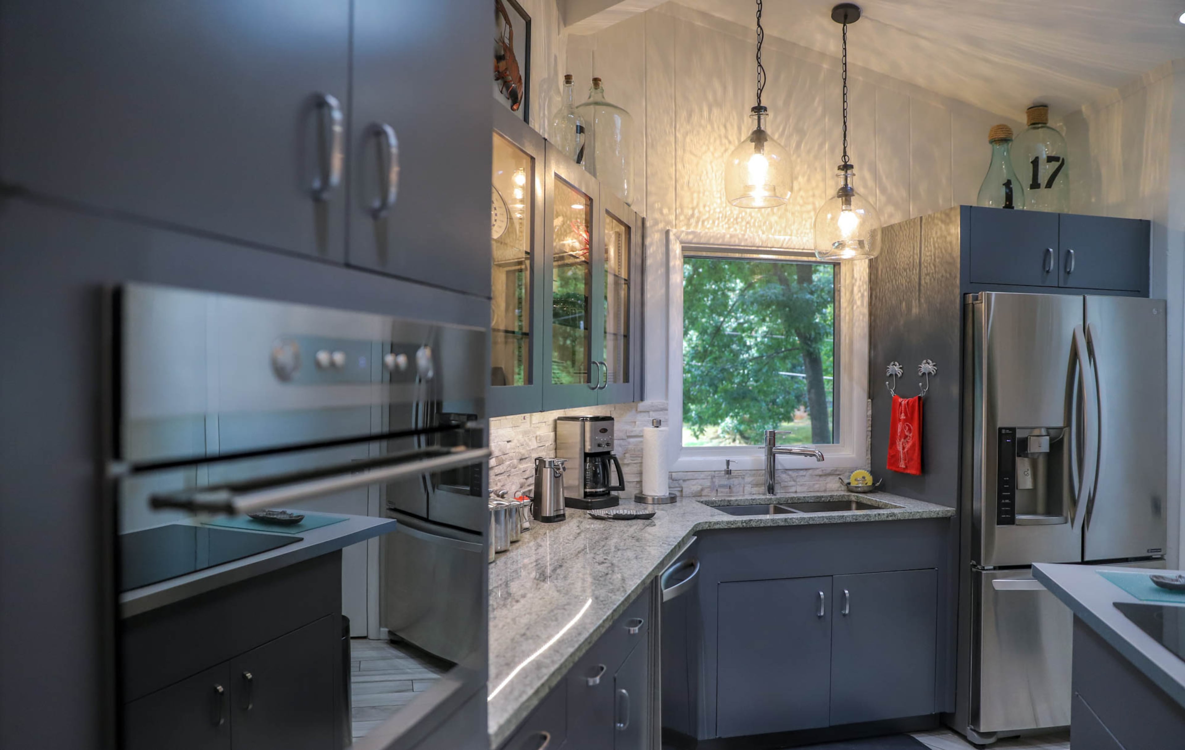 The Sandy Springs kitchen, illuminated by glass pendants and a window over the sink, is updated with stainless steel appliances by General Electric, LG and Kenmore.