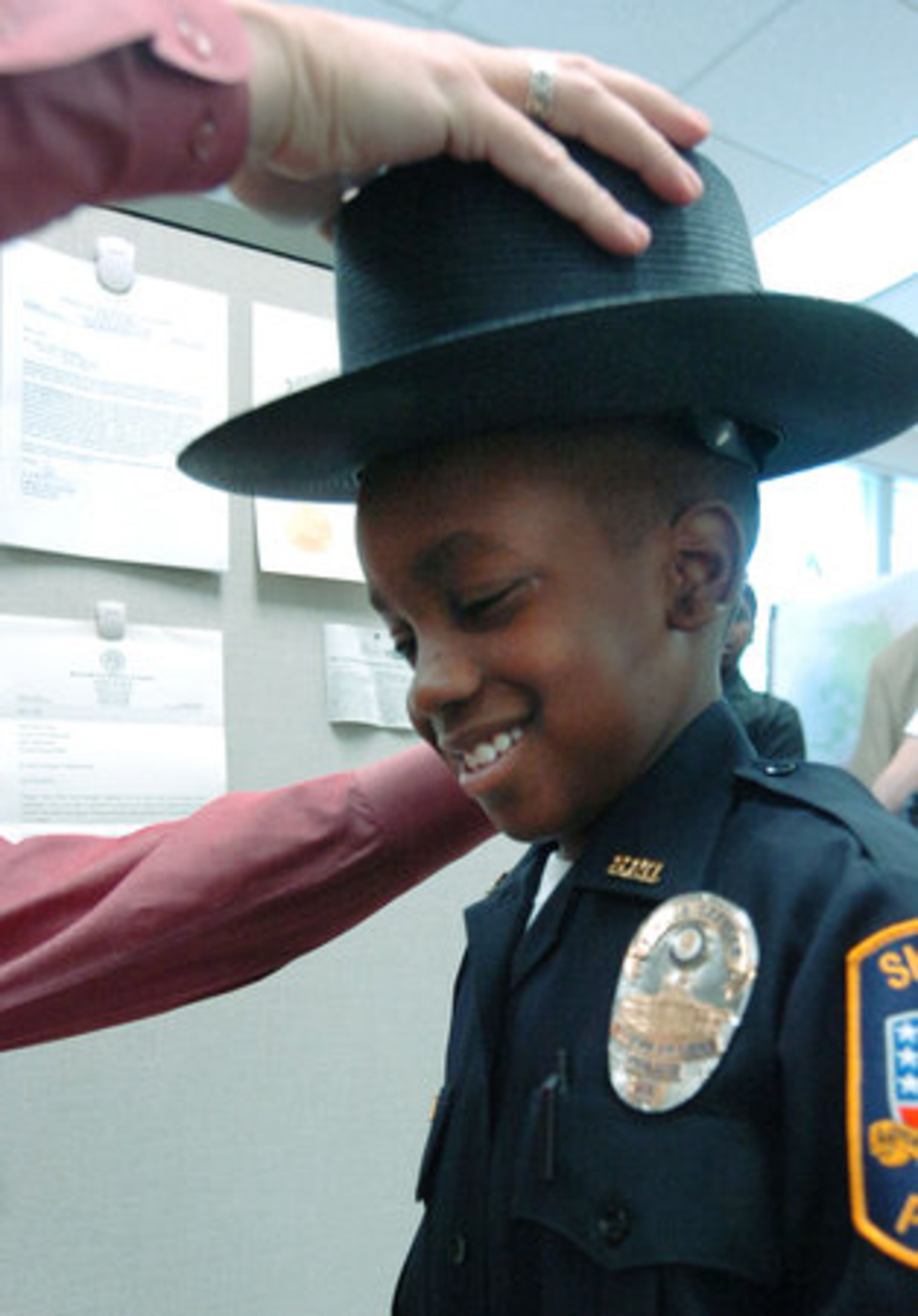 Smyrna Detective Ron Waddell helps Darrien with his hat.