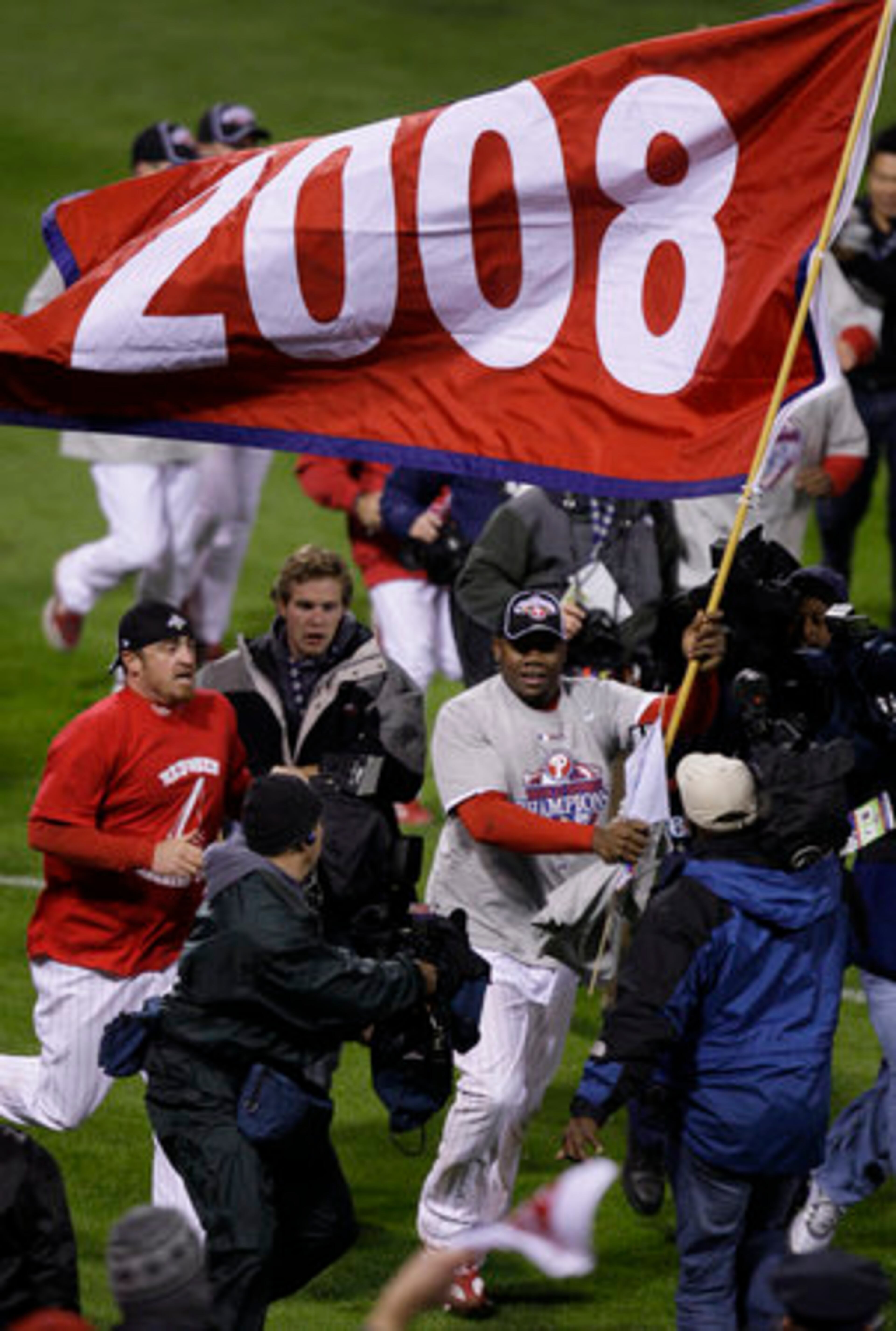 Ryan Howard carries a 2008 banner on the field after the victory.