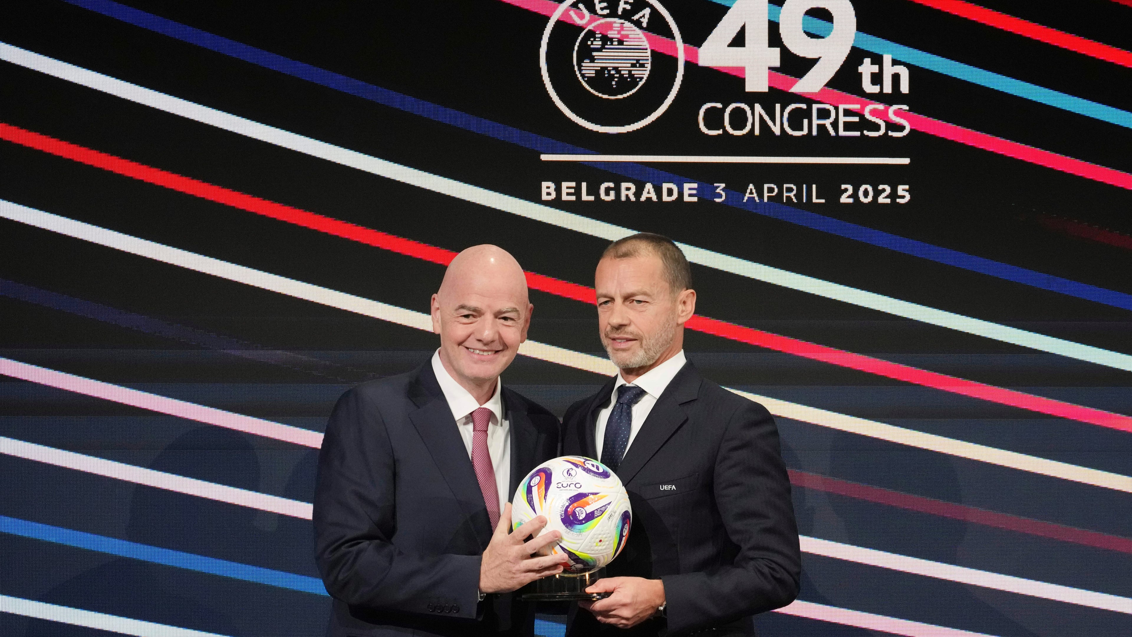 FILE - UEFA President Aleksander Ceferin, right, and FIFA president Gianni Infantino, left, holding a ball during the 49th UEFA congress in Belgrade, Serbia, April 3, 2025. (AP Photo/Darko Vojinovic, File)