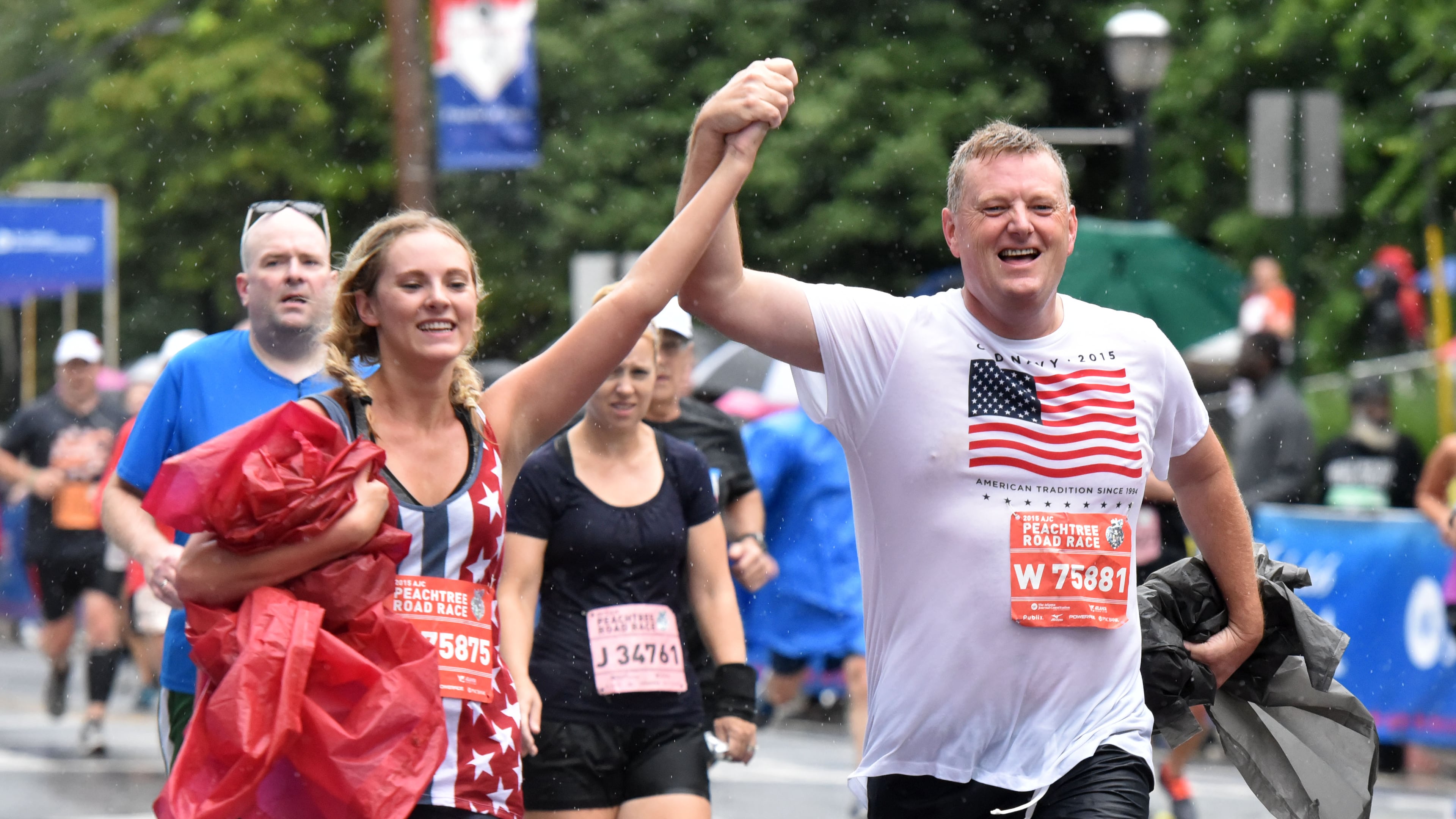 Runners react in different ways as they approach the finish line during the AJC Peachtree Road Race on Saturday, July 4, 2015. HYOSUB SHIN / HSHIN@AJC.COM