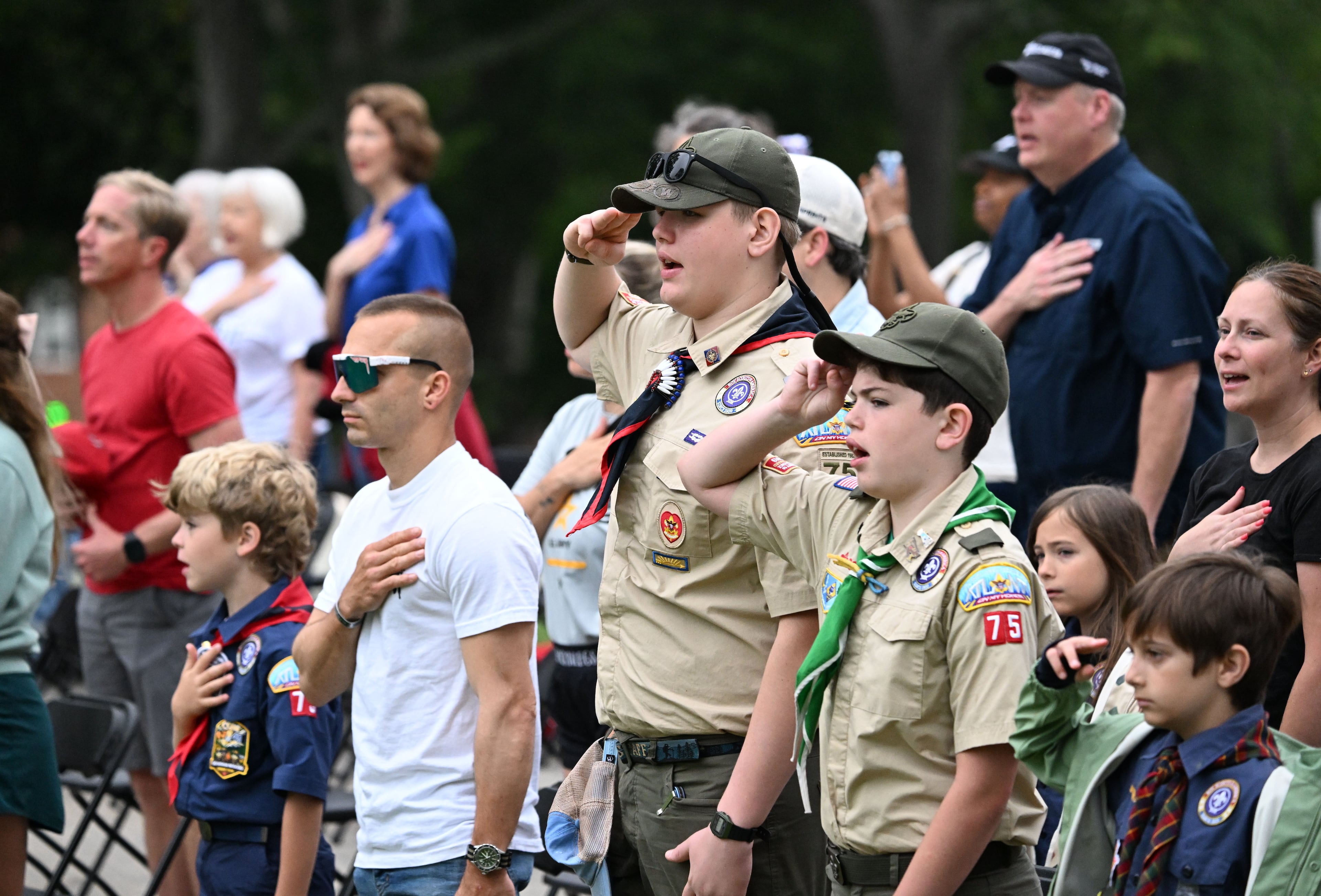 Scouts participate in an opening ceremony before the Memorial Day Flag Placement event at Marietta National Cemetery on Saturday, May 23, 2026, in Marietta. Scouting groups in the community place more than 18,000 U.S. veteran grave flags at Marietta National Cemetery each year on the Saturday before Memorial Day, helping prepare for Monday’s ceremony. The long-running service project—organized with the National Memorial Day Association of Georgia—also gives youth and adults an opportunity to honor fallen service members and learn about their sacrifices and the area’s history. (Hyosub Shin/AJC)