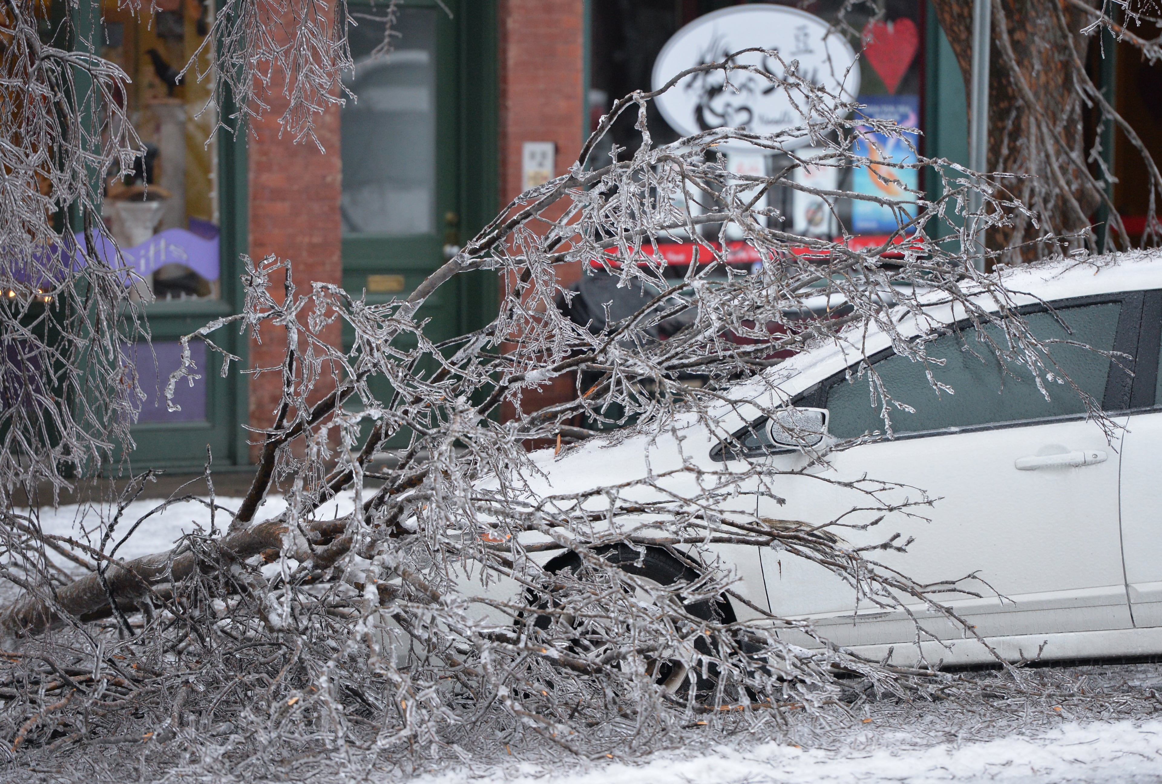 The ice storm caused many trees to break, trapping this car under heavy limbs on Broad Street in downtown Augusta on Thursday, February 13, 2014. HYOSUB SHIN / HSHIN@AJC.COM