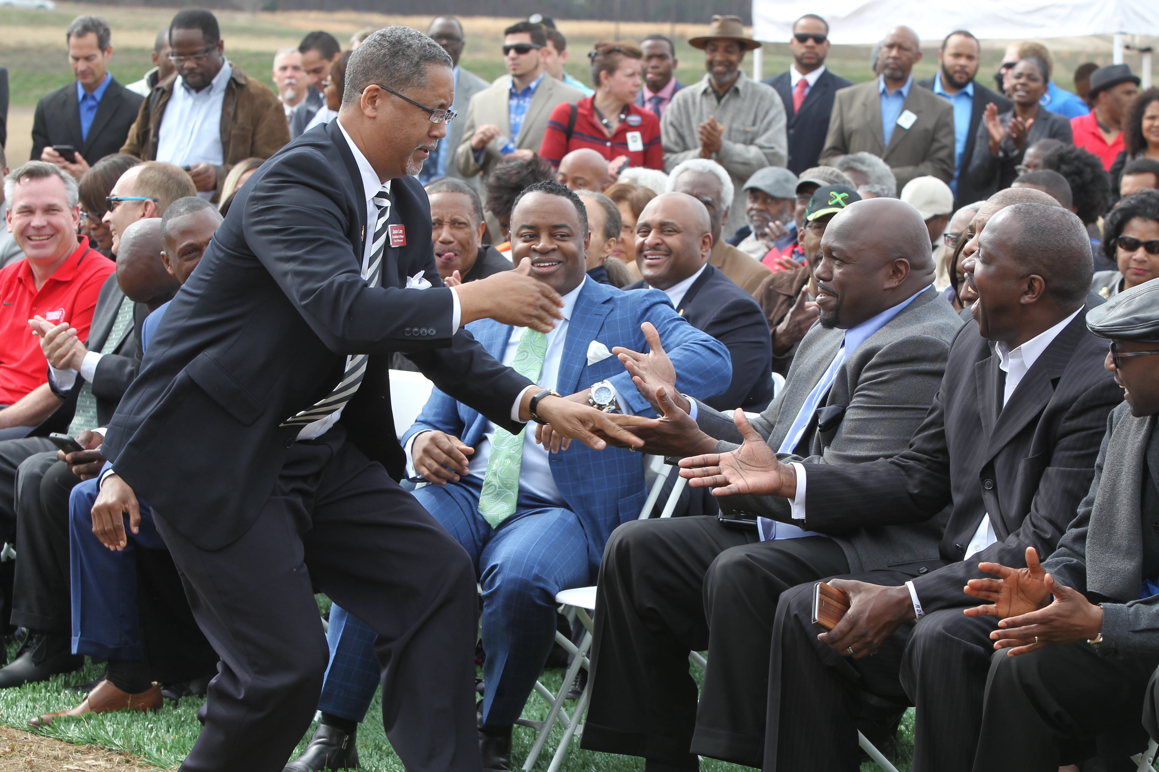 February 22, 2017, Atlanta, Georgia - Jason Larry, the President of Stonecrest Cityhood Alliance and a mayoral candidate gives fast high fives and palm slaps to the front row as he takes his place at the podium at the unveiling of the Atlanta Sports City sports complex site in Stonecrest, Georgia, on Wednesday, February 22, 2017. (HENRY TAYLOR / HENRY.TAYLOR@AJC.COM)