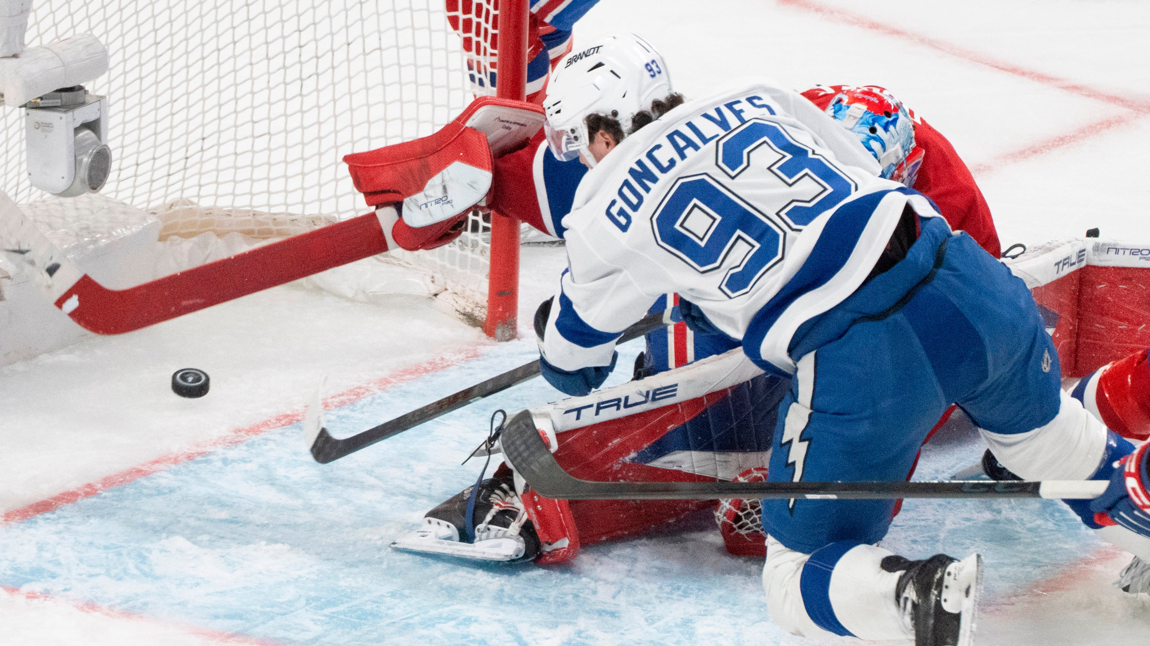 Tampa Bay Lightning's Gage Goncalves (93) scores against Montreal Canadiens goaltender Jakub Dobes, bottom, during overtime of Game 6 in the first round of an NHL hockey Stanley Cup playoff series in Montreal, Friday, May 1, 2026. (Christinne Muschi/The Canadian Press via AP)