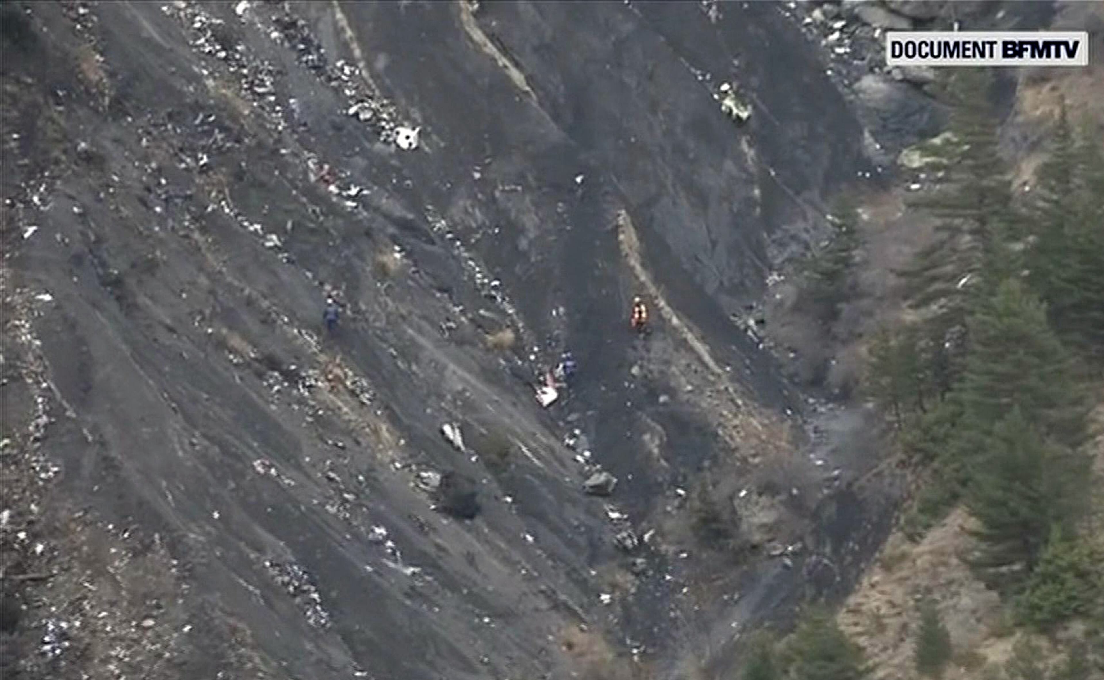 In this image made from TV, rescue workers search among the debris after a Germanwings Airbus 320 crashed in the French Alps, Tuesday, March 24, 2015. A Germanwings passenger jet carrying at least 150 people crashed Tuesday in a snowy, remote section of the French Alps, sounding like an avalanche as it scattered pulverized debris across the mountain. (AP Photo / BFMTV) FRANCE OUT TV OUT