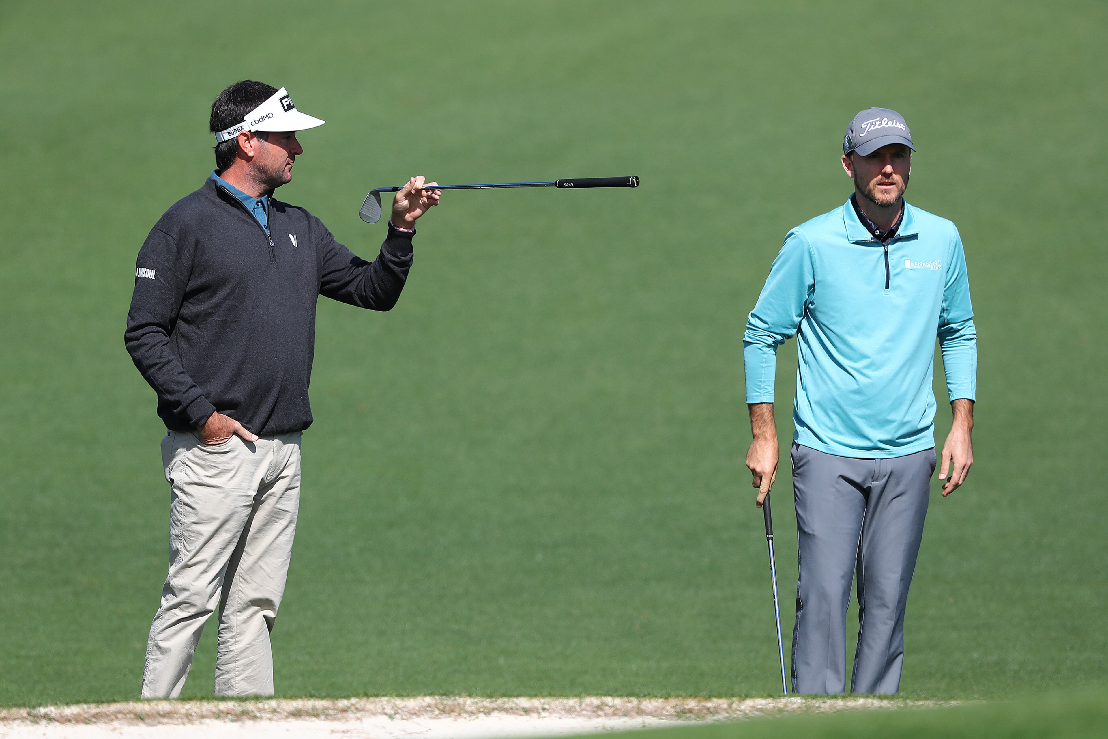 040422 Augusta: Two-time Masters champion Bubba Watson (left) gives fellow University of Georgia golfer Russell Henley some pointers on pin locations at the second green while they play a practice round for the Masters at Augusta National Golf Club on Monday, April 4, 2022, in Augusta. “Curtis Compton / Curtis.Compton@ajc.com”