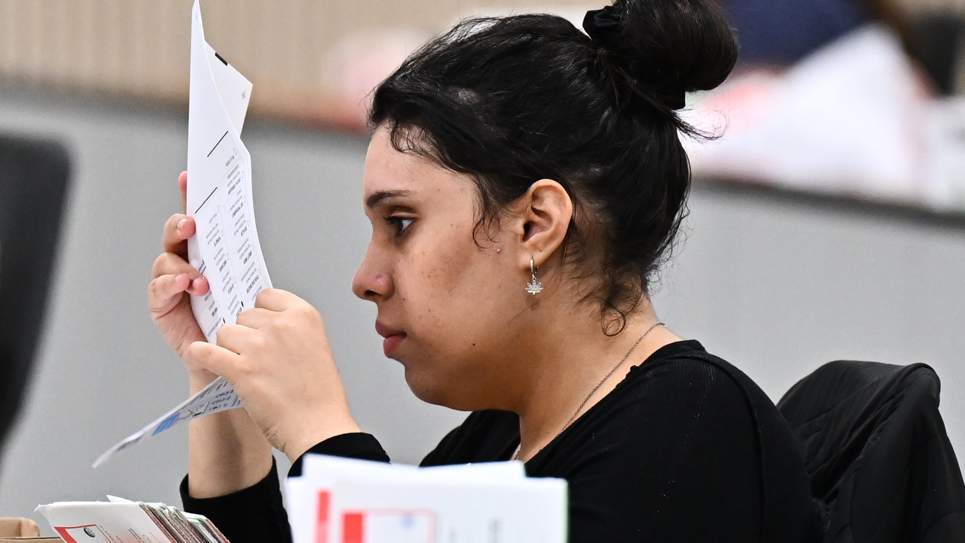 A worker inspects a ballot at the L.A. County Ballot Processing Center during the California primary election on Tuesday, June 2, 2026, in City of Industry, Calif. (AP Photo/William Liang)