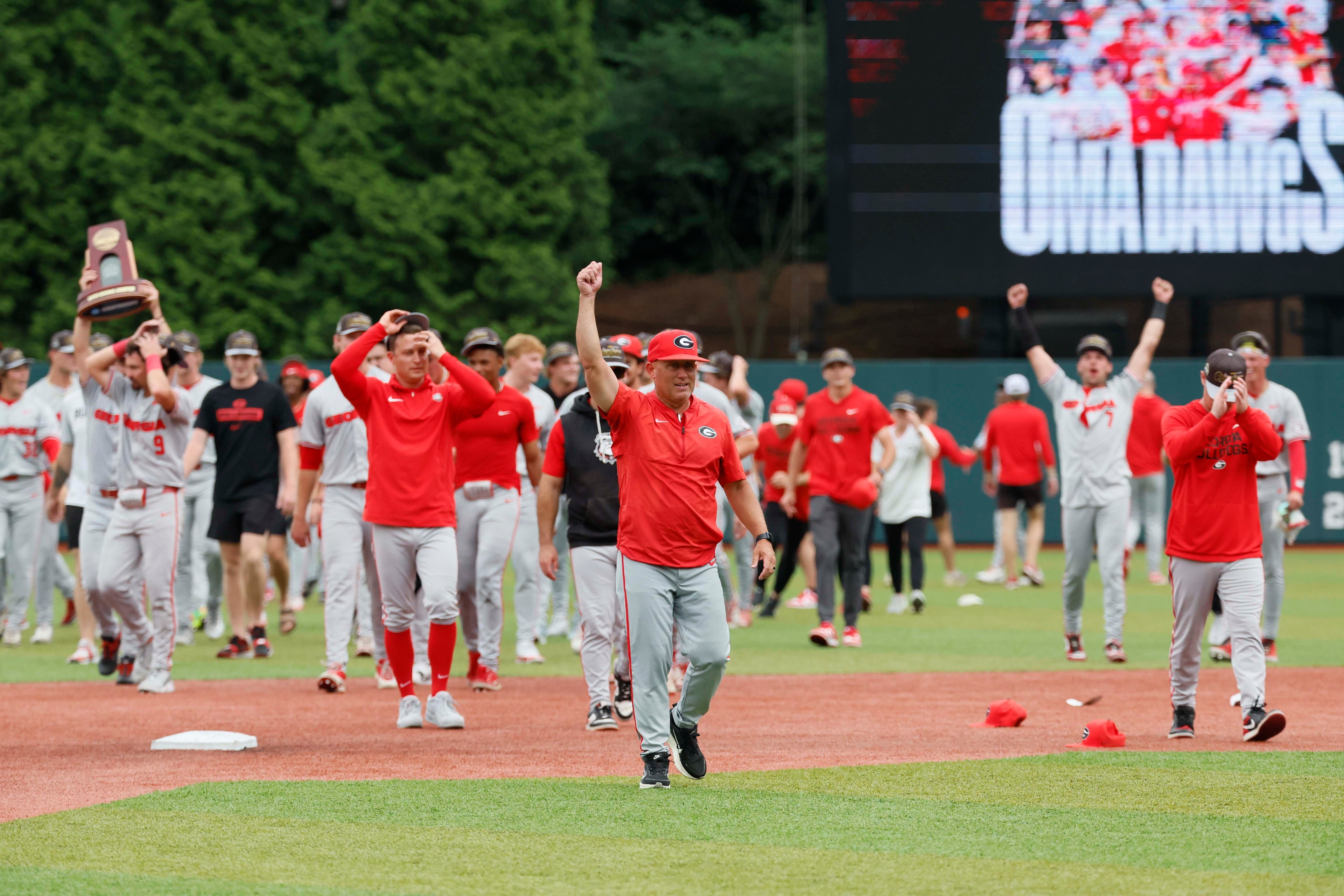 Georgia Bulldogs head coach Wes Johnson lifts her arm as he celebrates with his team after winning the NCAA Super Regional series by defeating the Mississippi State Bulldogs 11-9 in extra innings at Foley Field on Sunday, June 7, 2026, in Athens. Miguel Martinez/AJC)