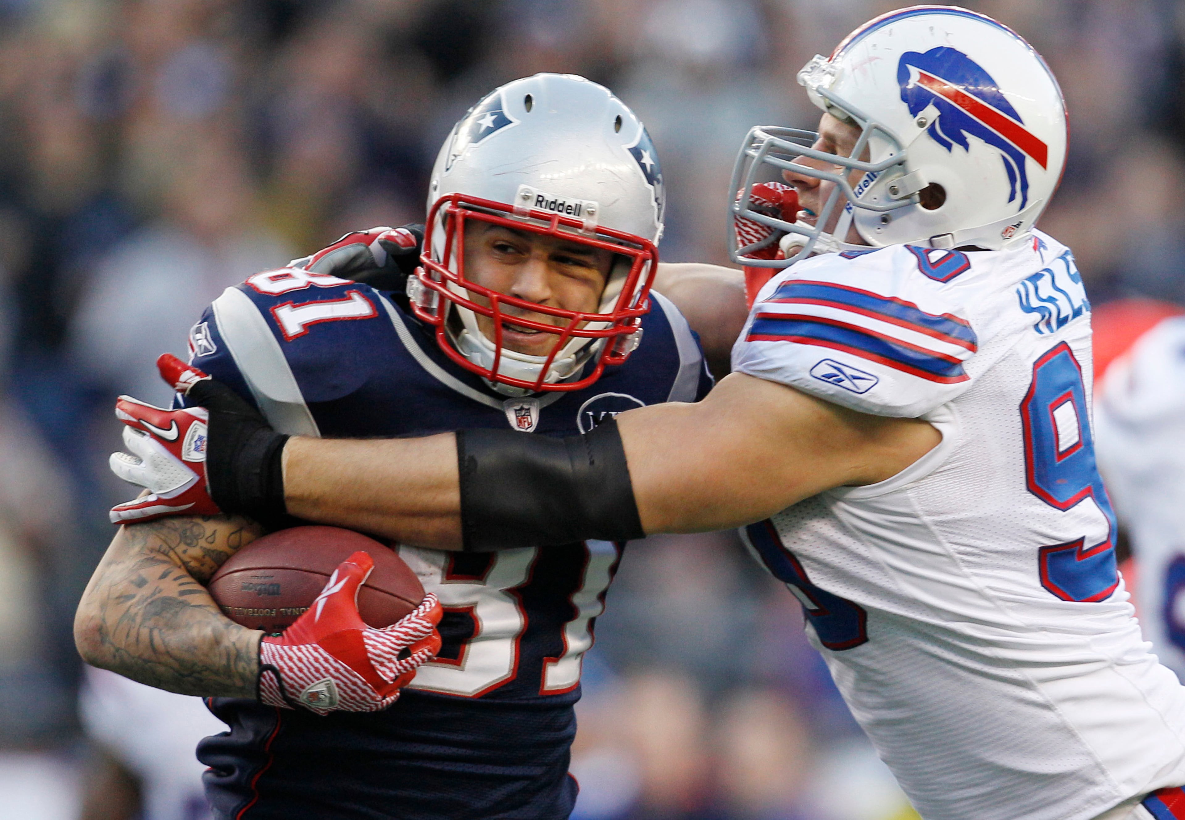 New England Patriots tight end Aaron Hernandez (81) tries to break free of Buffalo Bills linebacker Chris Kelsay (90) during the fourth quarter of an NFL football game in Foxborough, Mass.