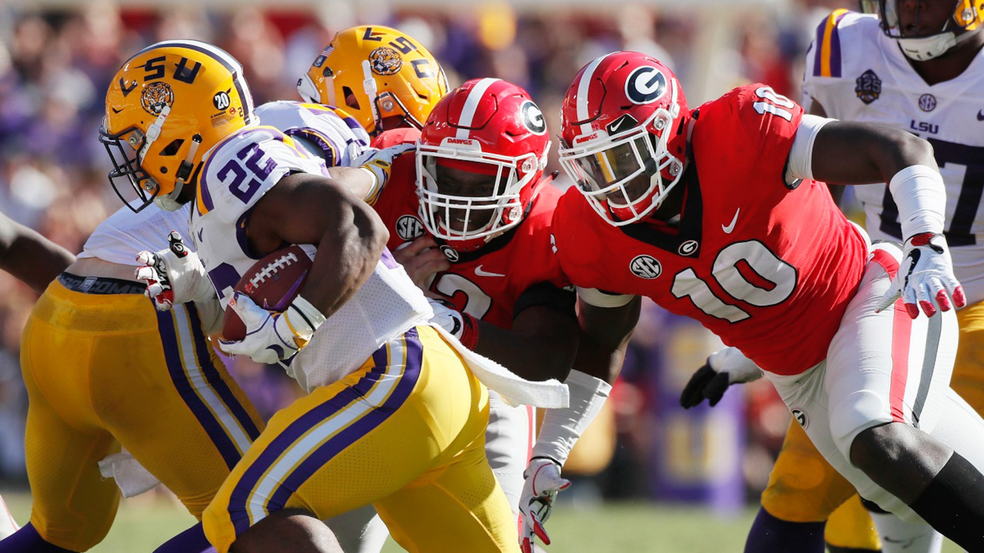 LSU running back Clyde Edwards-Helaire (22) evades Georgia defensive lineman Malik Herring (10) and a teammate Saturday, October 13, 2018, at Tiger Stadium in Baton Rouge, LA. BOB ANDRES / BANDRES@AJC.COM