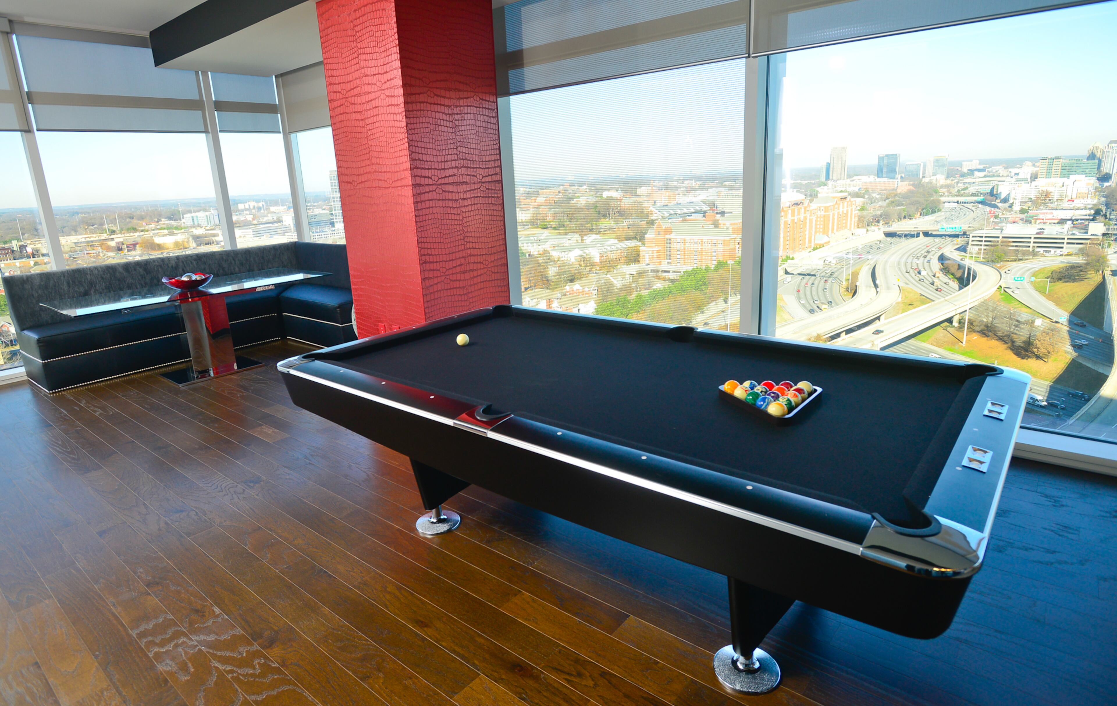 Visitors can't miss the pool table, which is in the middle of the condo, between the kitchen and dining area and the sitting area. Atlanta decorative artist Kathy Hynes provided the idea for red faux crocodile pattern. -- Text by Lori Johnston
