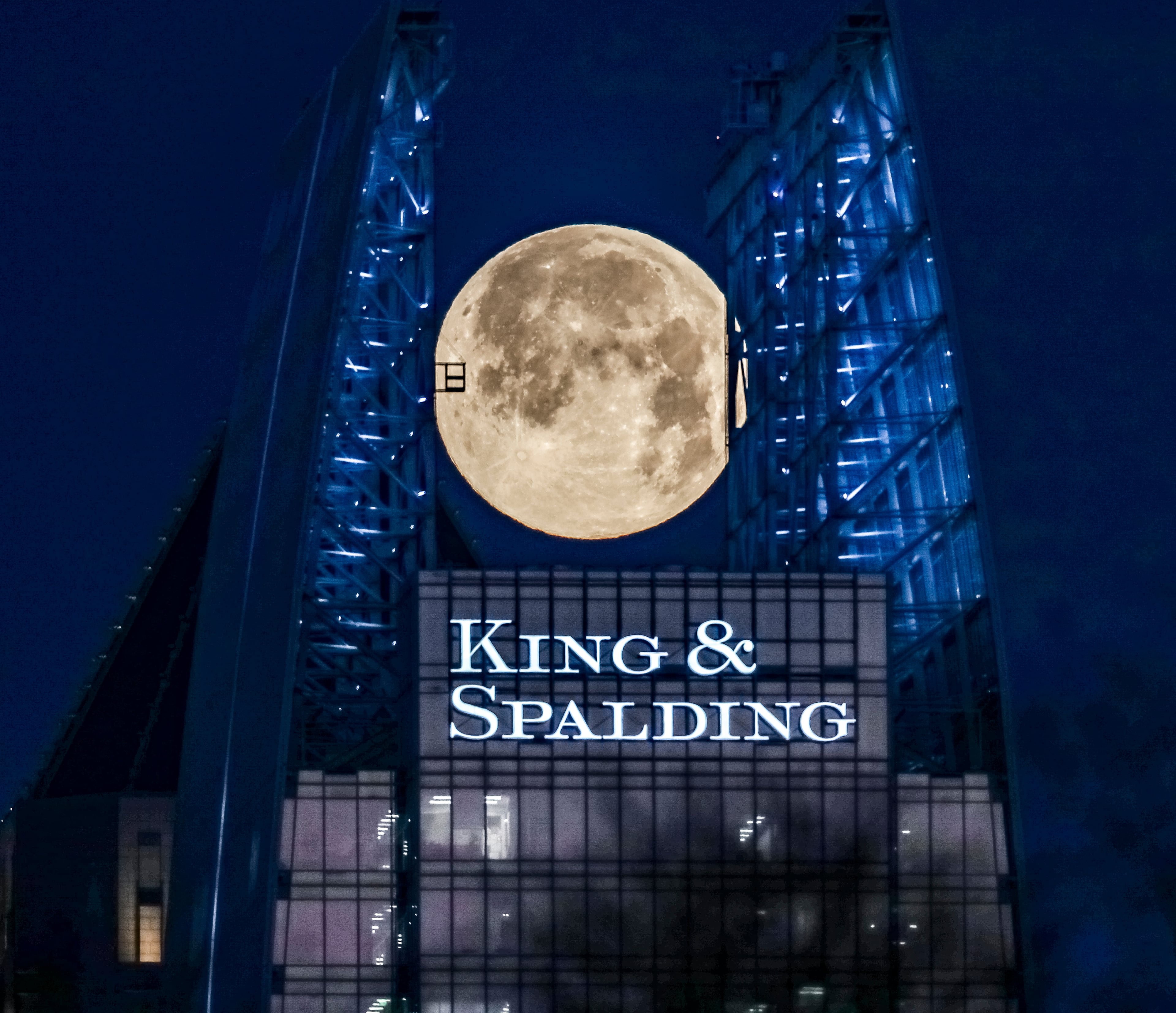 March 7, 2023 Atlanta: The full Worm Moon reached its peak illumination Tuesday morning March 7, 2023 seen here sandwiched between the two glass fins extending upwards from the north and south walls of the 657 foot tall 1180 Peachtree building, also known as Symphony Tower in midtown Atlanta. (John Spink / John.Spink@ajc.com)