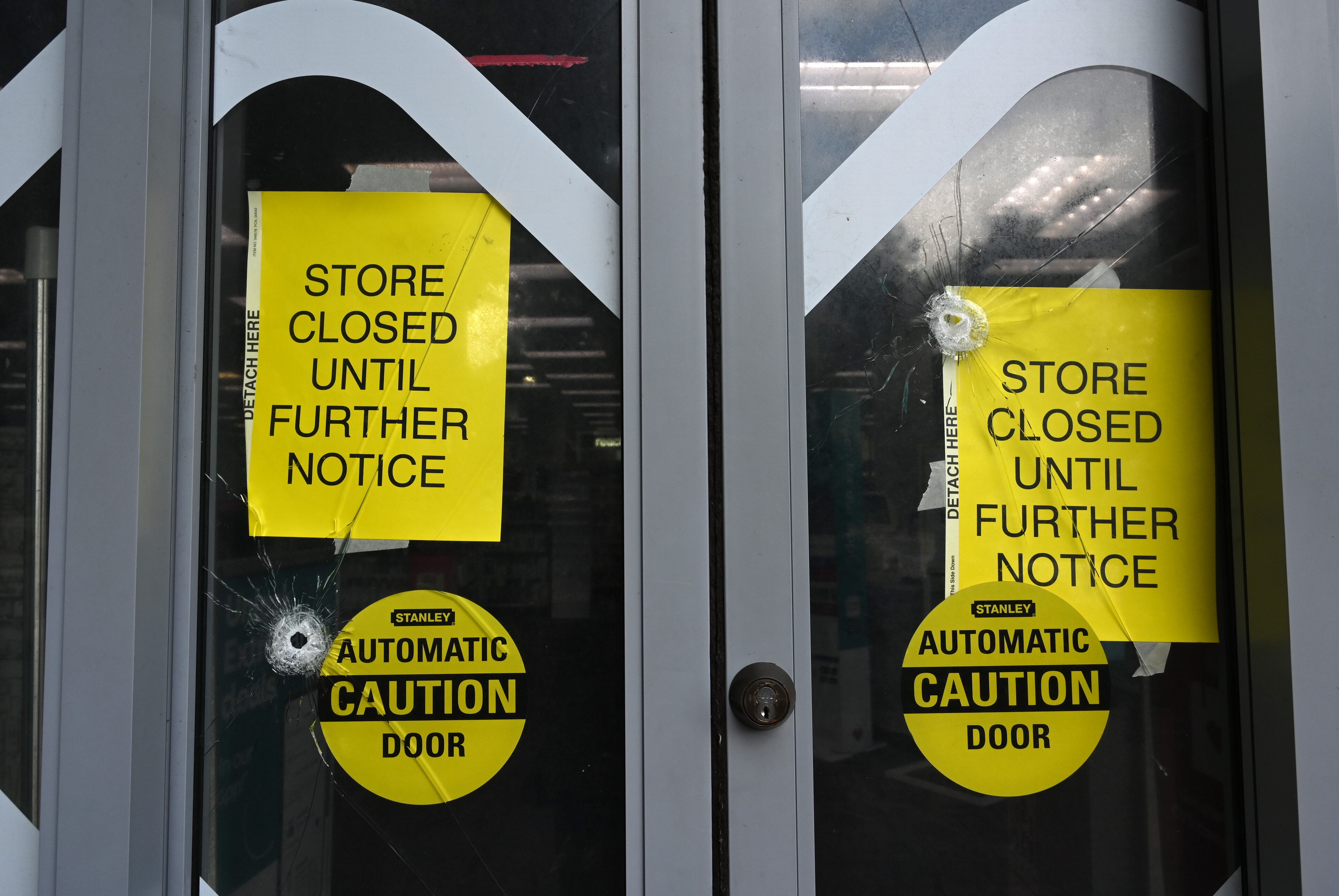 At least two bullet holes pierced through a CVS door at Emory Point in Friday's deadly shooting in the area of the Centers for Disease Control and Prevention and neighboring Emory University. (Hyosub Shin/AJC)
