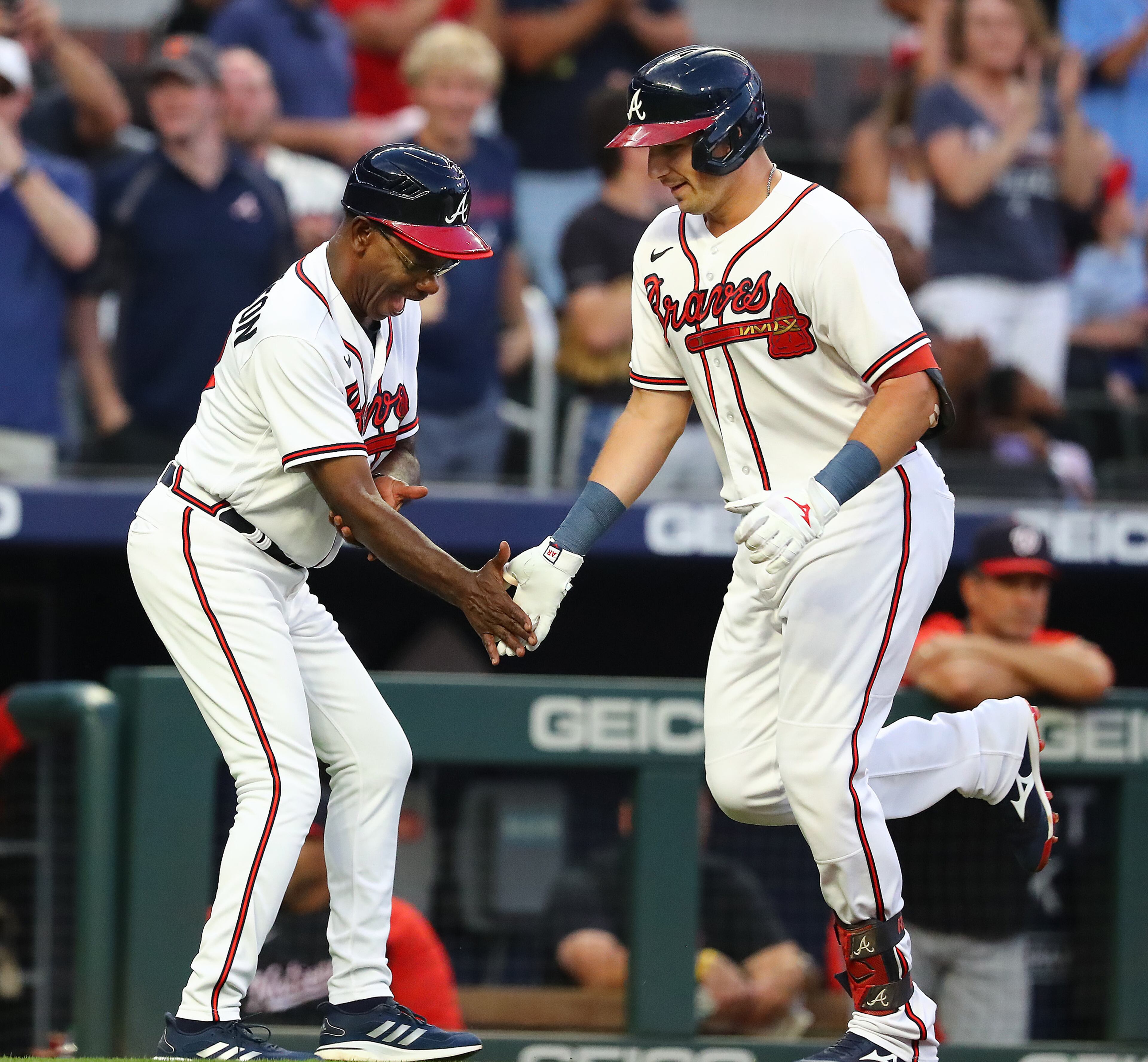 Braves third baseman Austin Riley gets five from third-base coach Ron Washington after Riley hit a solo home run against the Nationals on Monday night at Truist Park. (Curtis Compton / Curtis Compton@ajc.com)
