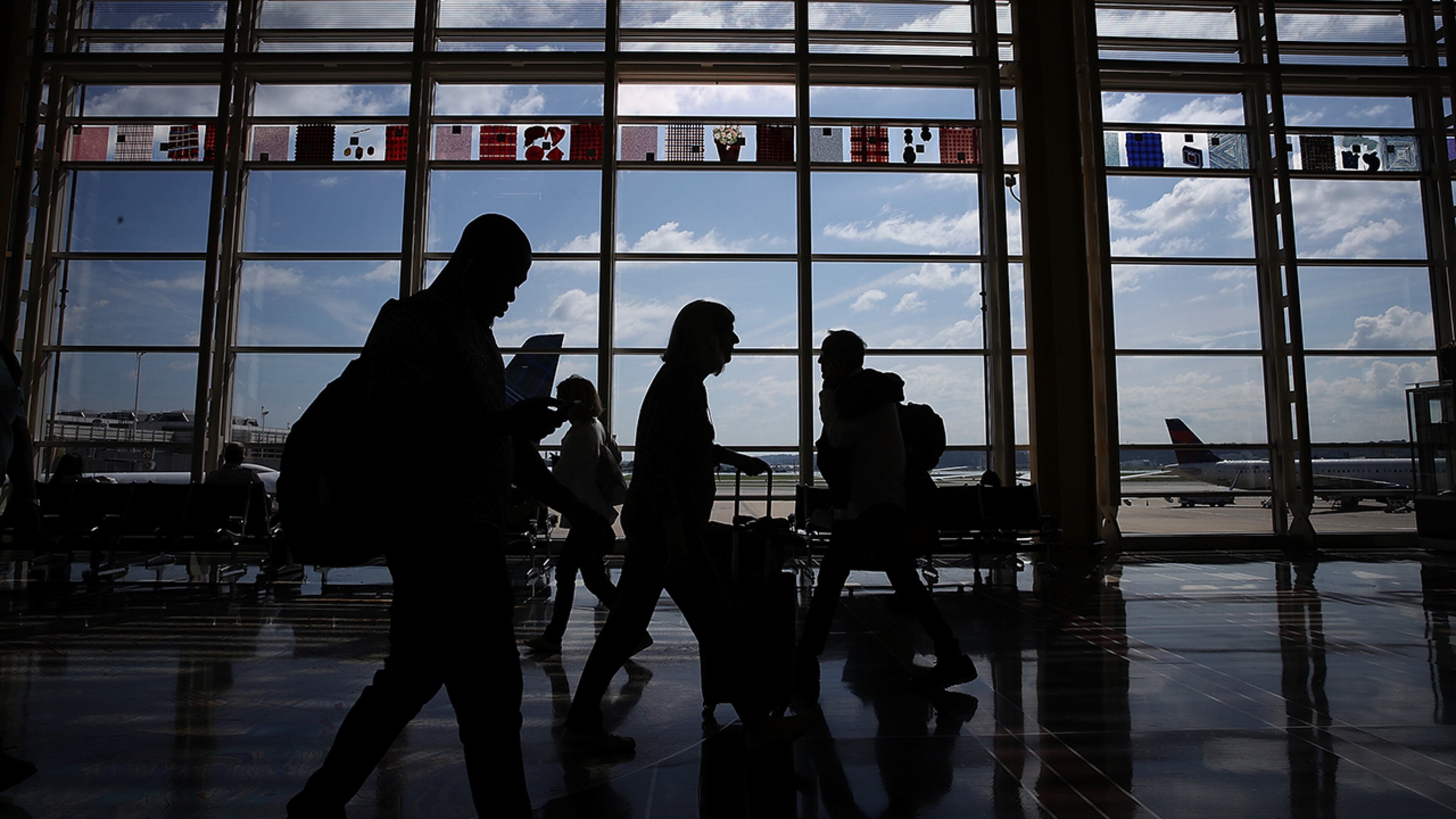 WASHINGTON, DC - JUNE 29: Travelers walk to their gates in the concourse of Reagan National Airport in Washington, DC. (Photo by Win McNamee/Getty Images)