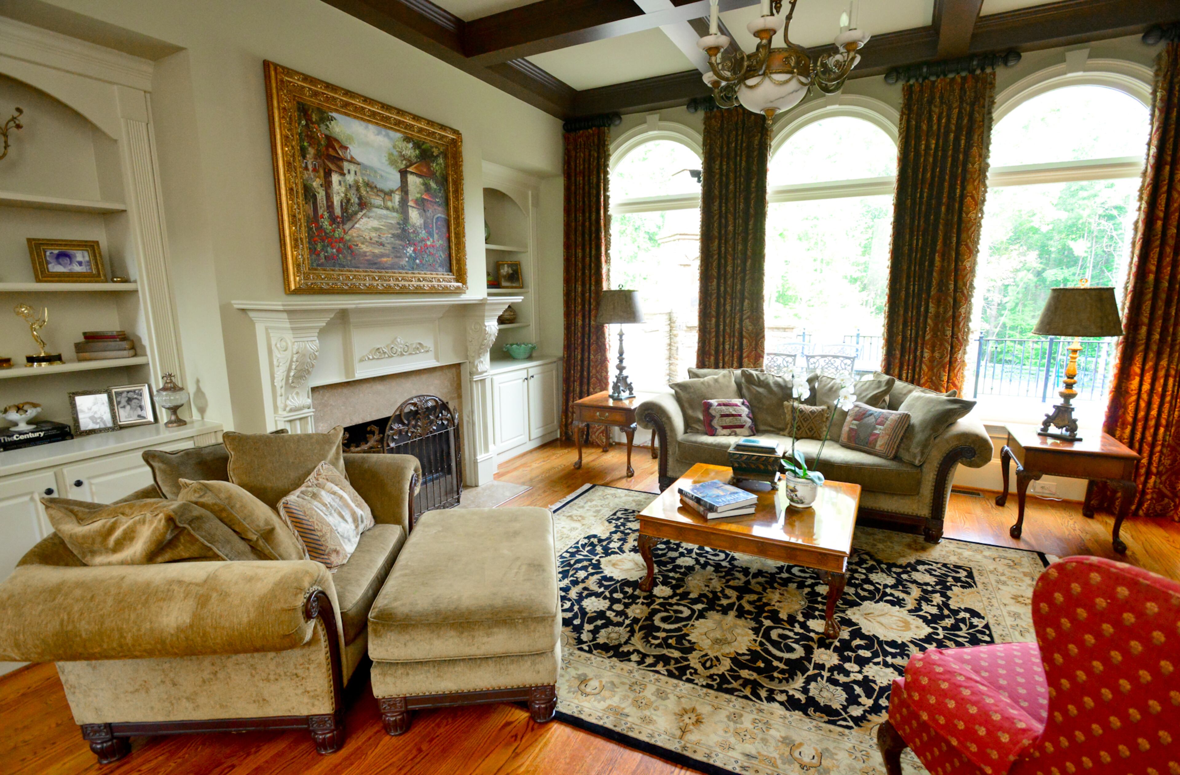 The living room has three large arched windows with spacious views of the pool, play area and beyond. Interior design style: “Old world meets Gothic meets Tuscan,” as described by Lisa. -- Text by Lori Johnston